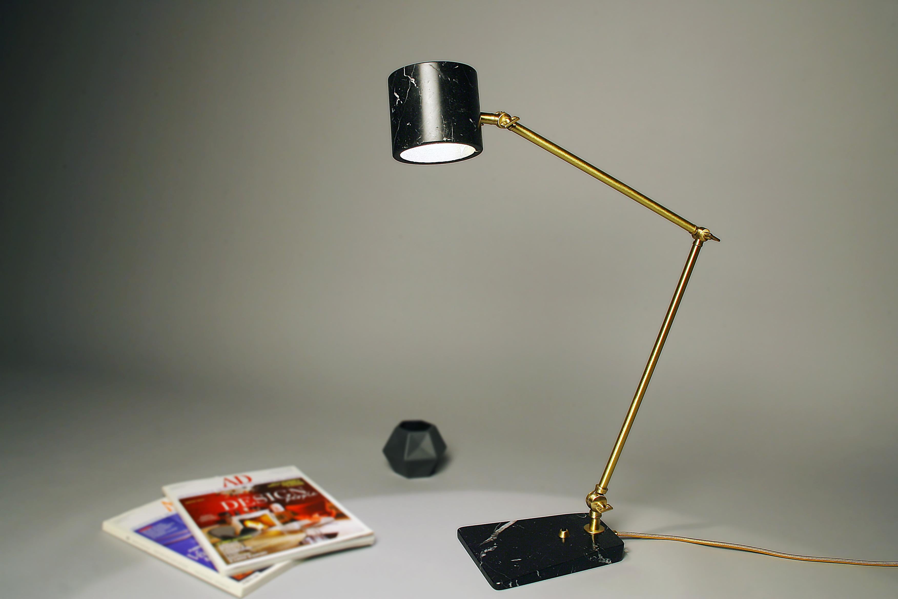 The Flamingo desk lamp is characterized by the contrast between the volumes of its elements: the thinness of the adjustable angle brass stem contrasts with the unusual adjustable marble shade.