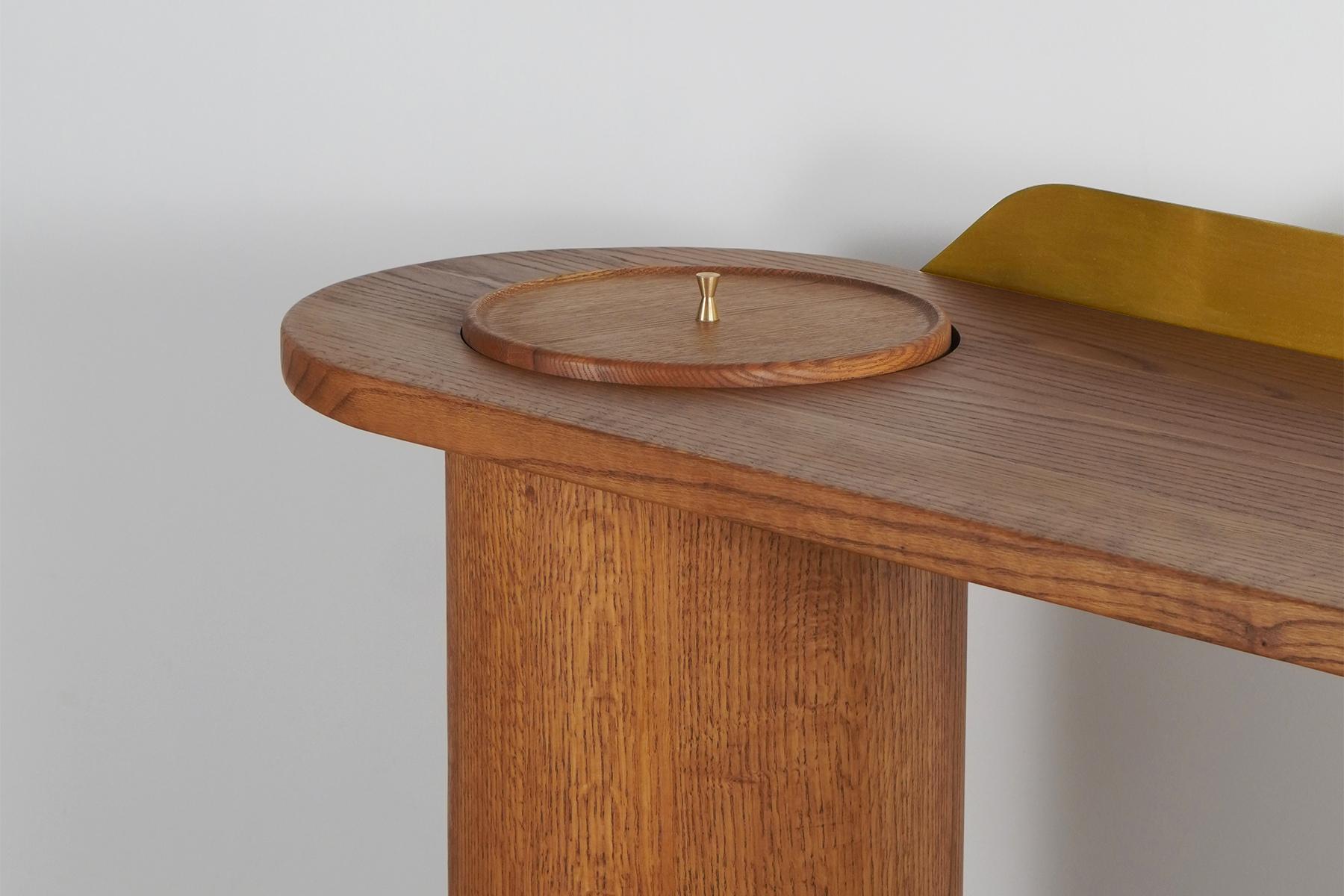The Meson Study Desk is a harmonious blend of sculptural elegance and functional design, transforming the mundane task of work into an elevated experience. Its unique silhouette, defined by two robust cylindrical legs supporting an organically
