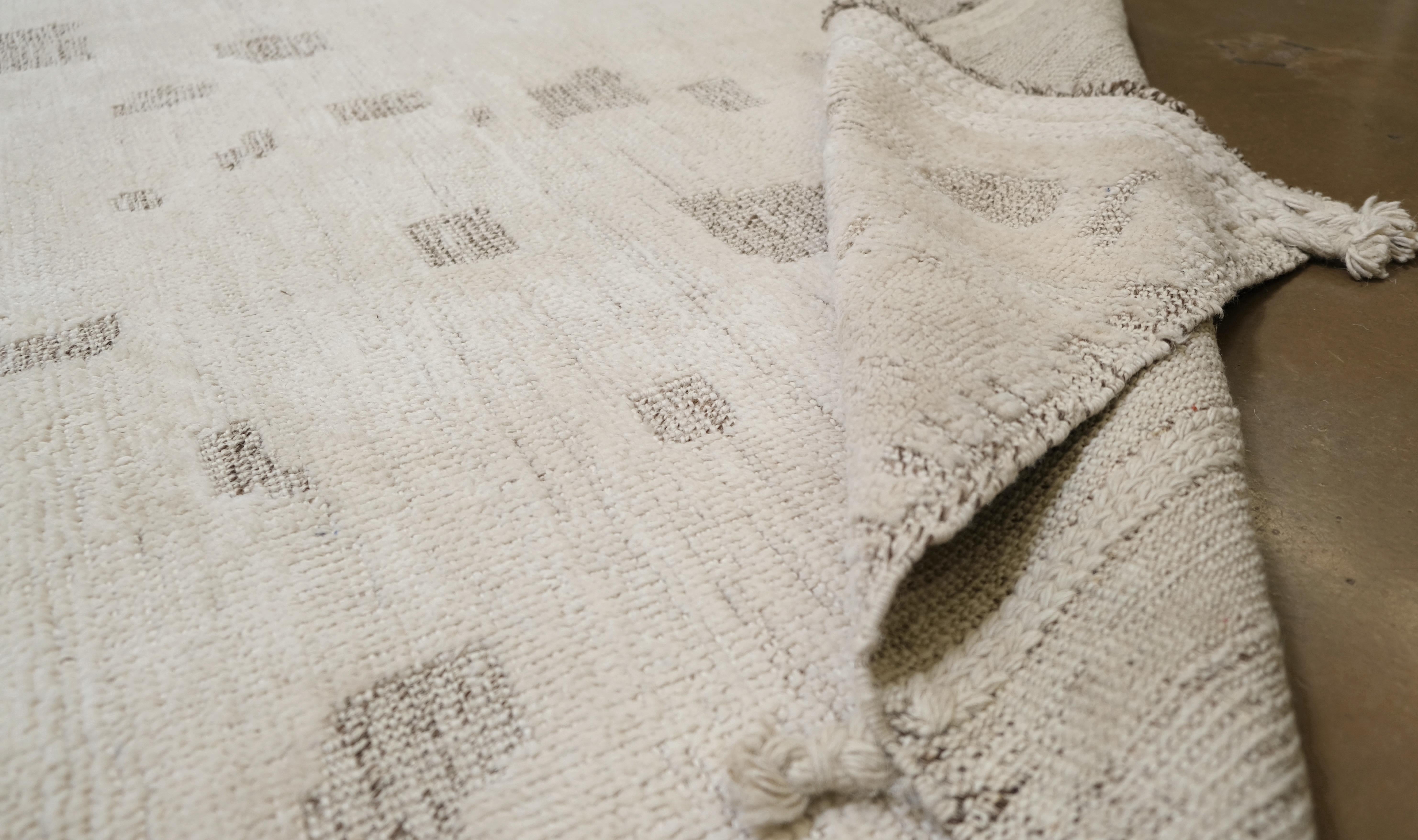 Verschönern Sie Ihr Interieur mit dem subtilen Charme dieses handgeknüpften Wollteppichs aus Pakistan. Mit seinem raffinierten abstrakten Design aus verstreuten geometrischen Elementen in neutralen Tönen verleiht dieser Teppich jedem Raum eine