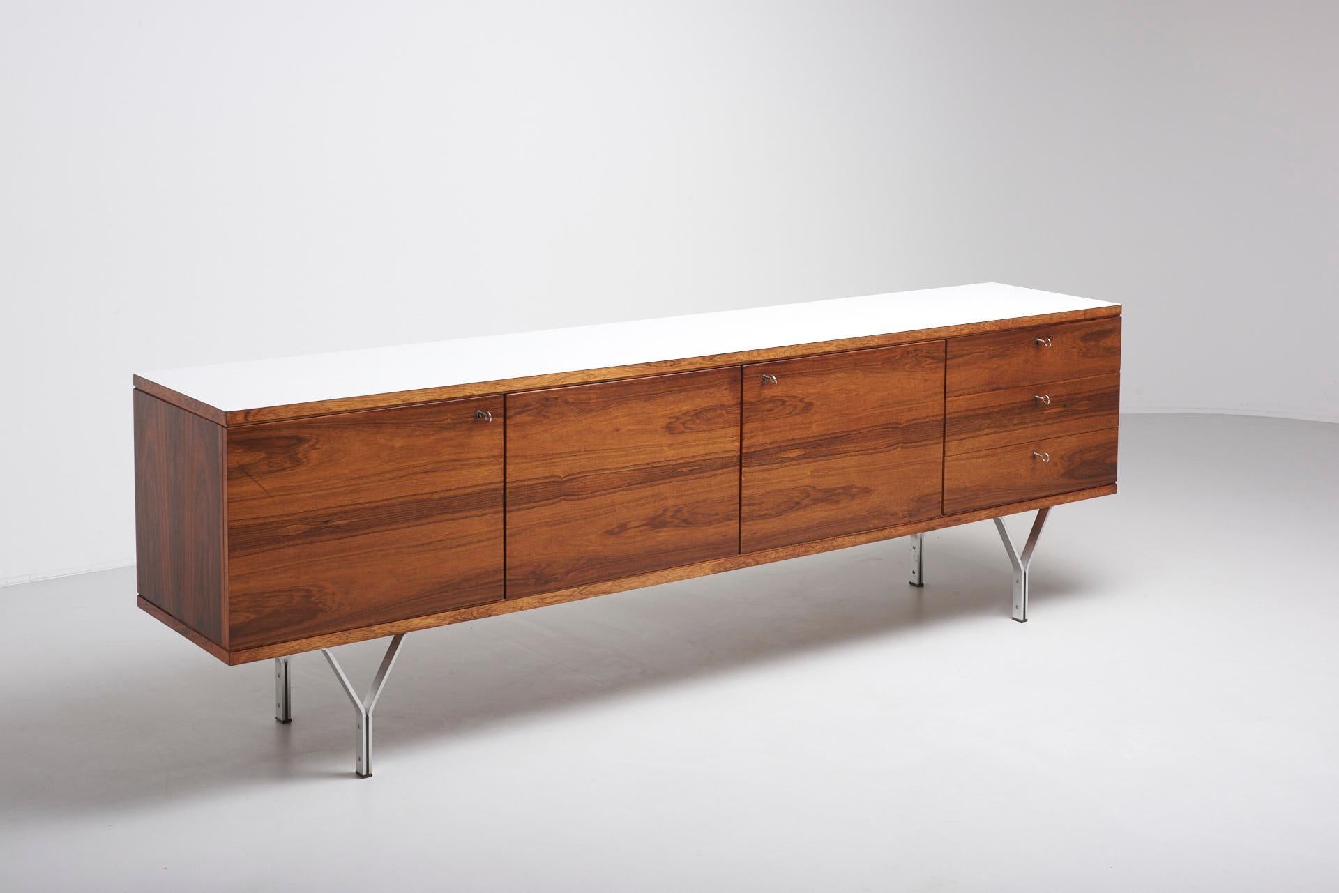 Minimal sideboard in Rio Palissander with legs in stainless steel and top in white laminate.
Made in Germany in 1960s.