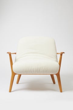 Poltrona Insigne in stile minimale scolpita in legno massiccio di noce, tessuti