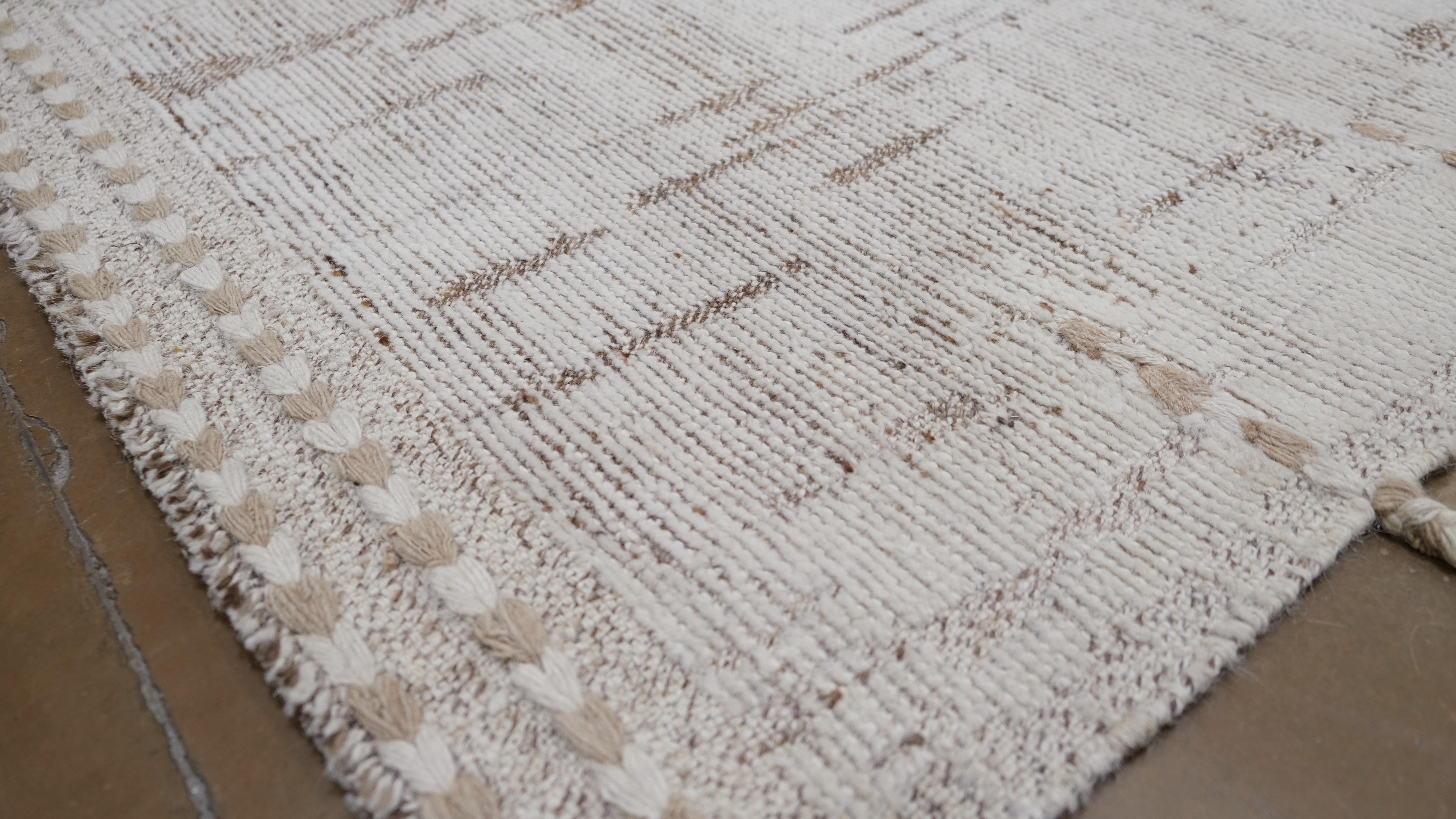 Bringen Sie Eleganz und Struktur in Ihren Raum mit diesem handgeknüpften Wollteppich. Mit seinem raffinierten abstrakten Design in neutralen Braun- und Beigetönen verbindet dieser Teppich nahtlos moderne und traditionelle Ästhetik und ist damit eine