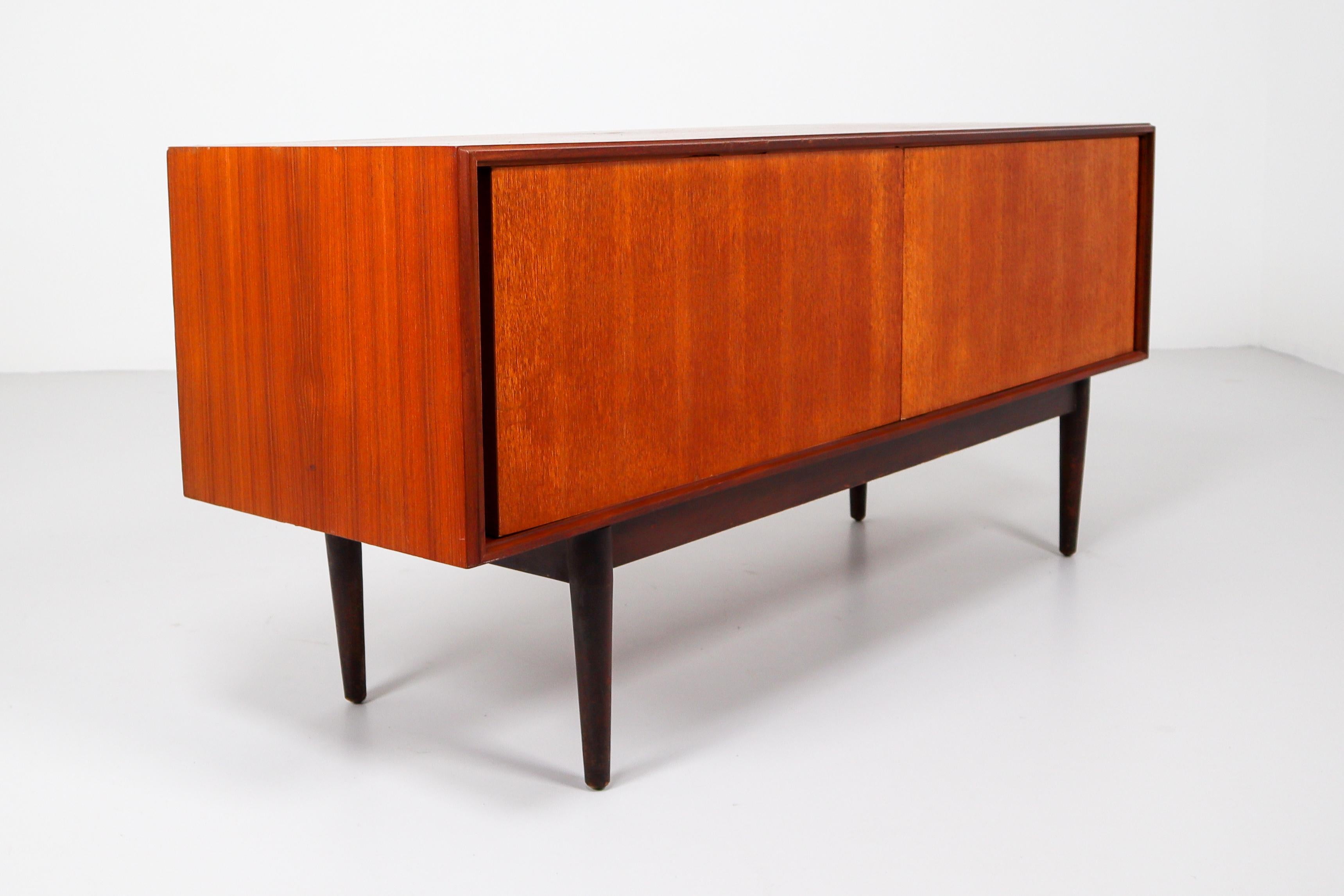 Simply teak sideboard from the 1960s made in Denmark in a smooth design where the beautiful wood grain falls into focus on the two sliding doors. This sideboard will contribute to a luxurious character of the interior Preserved in good condition and