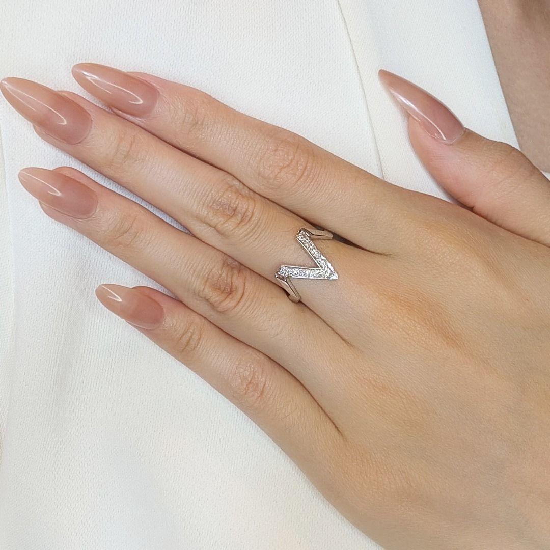 This V-shaped ring is a modern and elegant piece, crafted in radiant 14K white gold. Featuring 9 natural round brilliant diamonds totaling 0.13ct, with H color and SI clarity, it sparkles with subtle charm and sophistication. Weighing 3.52g and