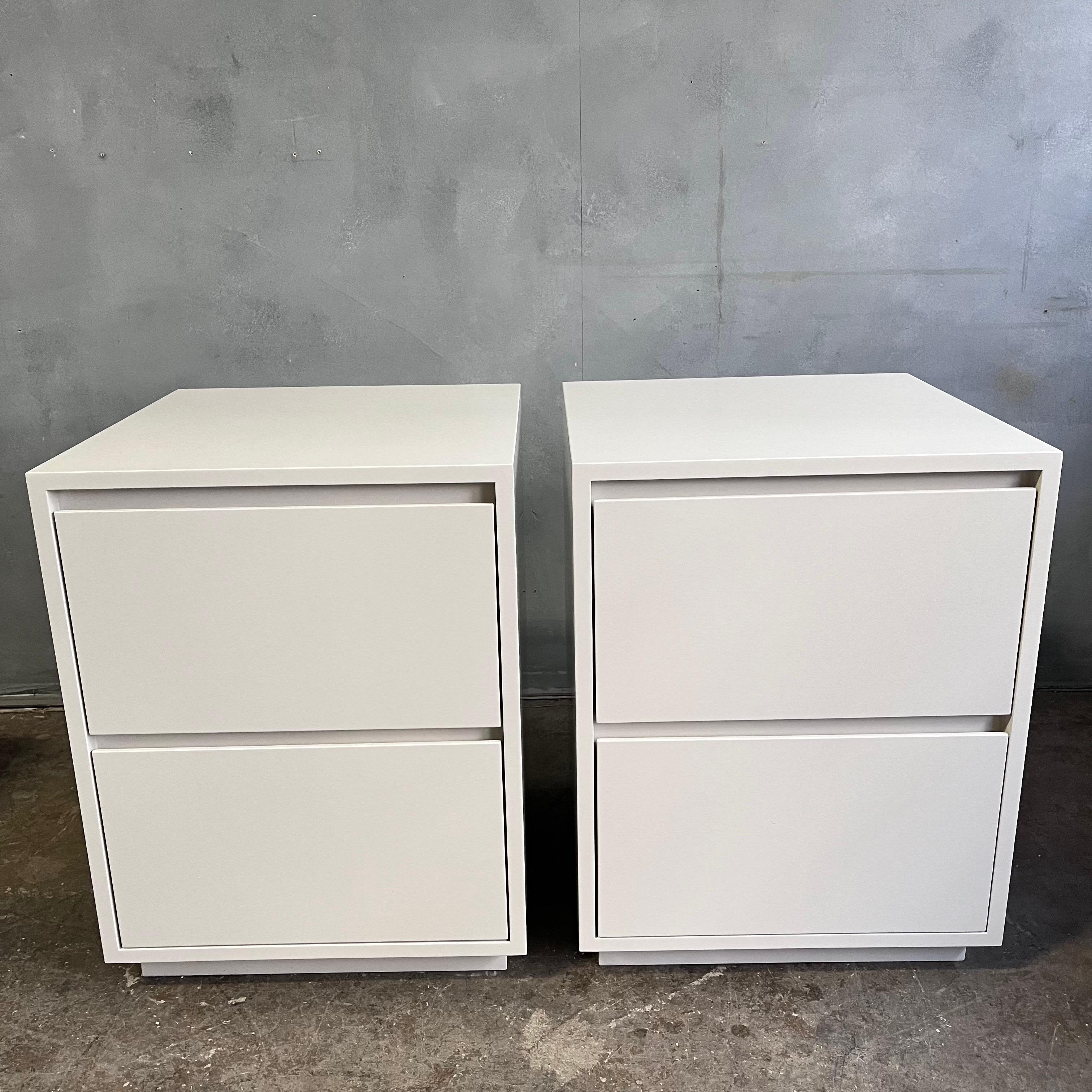 Beautiful and highly crafted nightstands or bedside tables each featuring two drawers in a heavy satin lacquer finish open a floating plinth base. All sides, interior, and back has been finished. Each drawer has soft close mechanisms. Showing almost