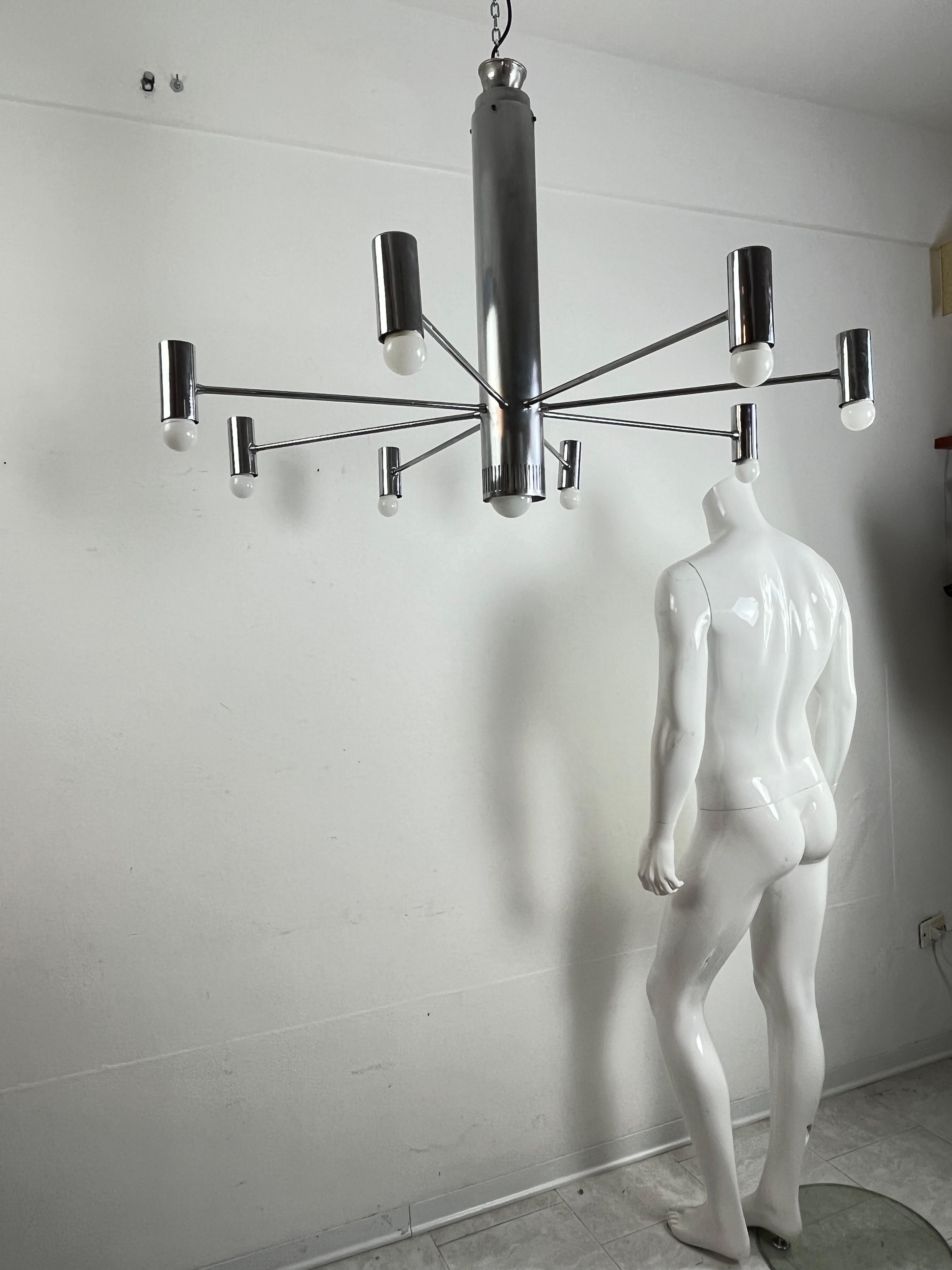 Minimalist 9-light steel chandelier attributed to Angelo Brotto, 1970s
Very large, it has a diameter of 104 cm.
One central E27 lamp and eight on the arms with E14 socket.
Intact and in good condition. Small signs of aging.
It will be shipped