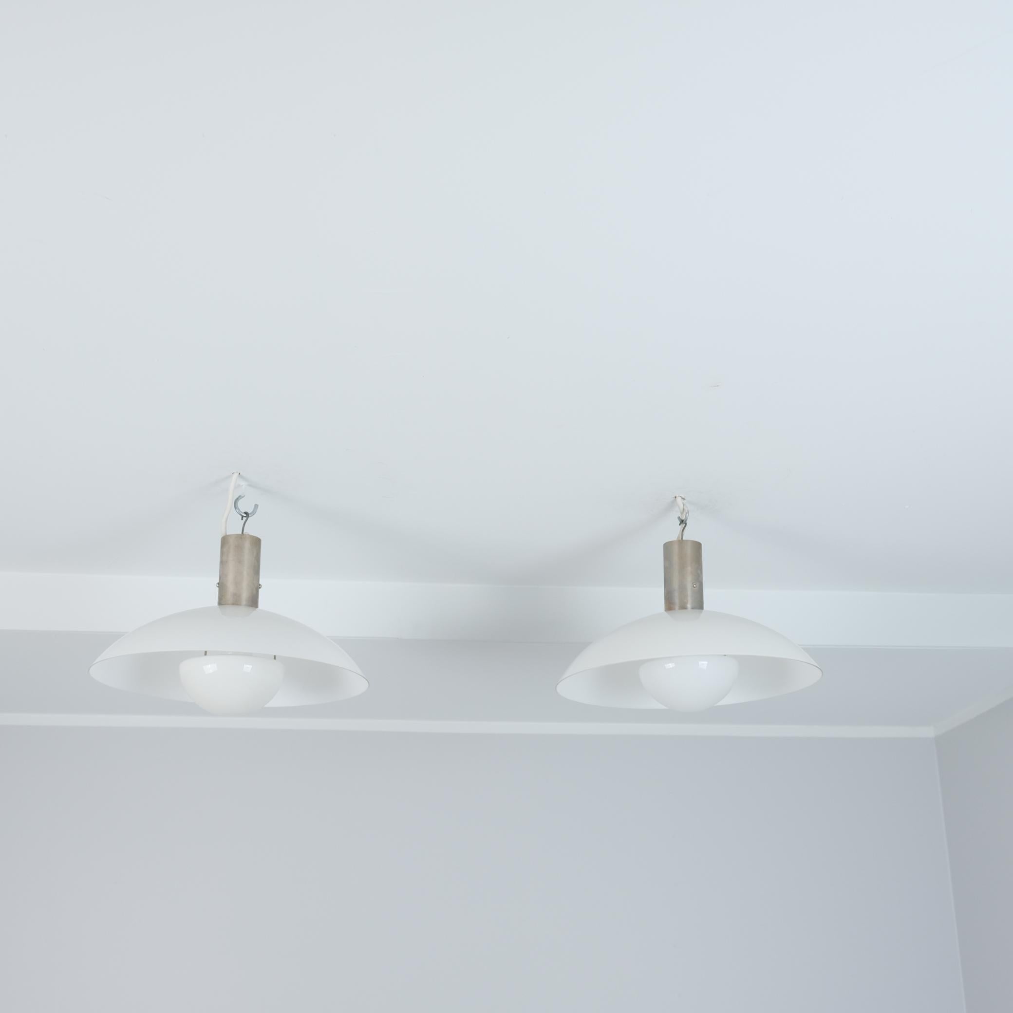 Une élégante paire de suspensions de plafond art déco minimaliste par Paavo Tynell et fabriquée par Taito dans les années 1930. Cette paire, ainsi que d'autres lampes figurant sur nos listes, provient du bâtiment Ilveslinna à Jämsänkoski et a été