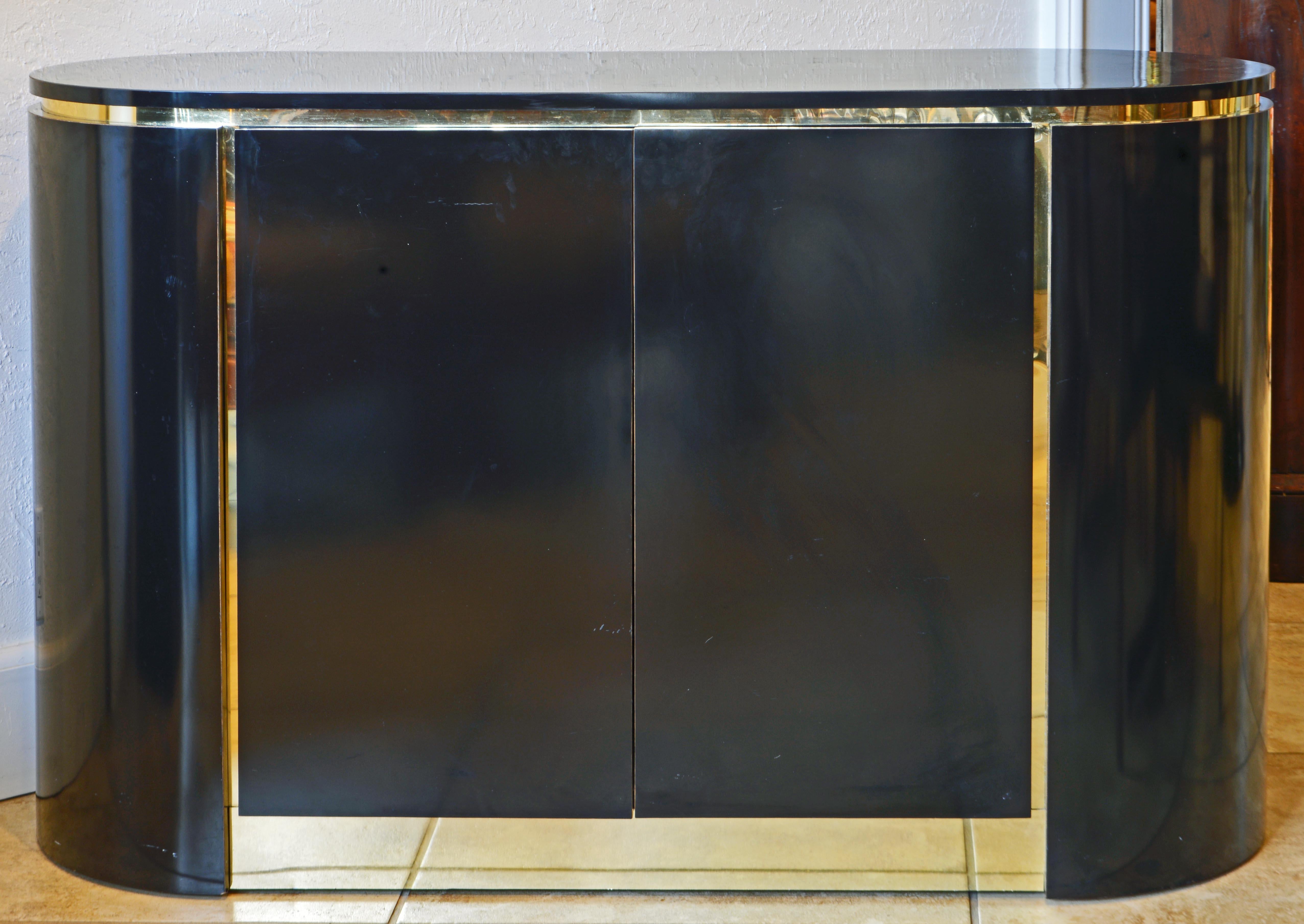 The small size makes this sideboard or credenza very versatile. It can be used as an entryway console, home bar or traditional credenza. It is shaped with rounded ends and two doors opening up to a shelved interior with one utility drawer. The black