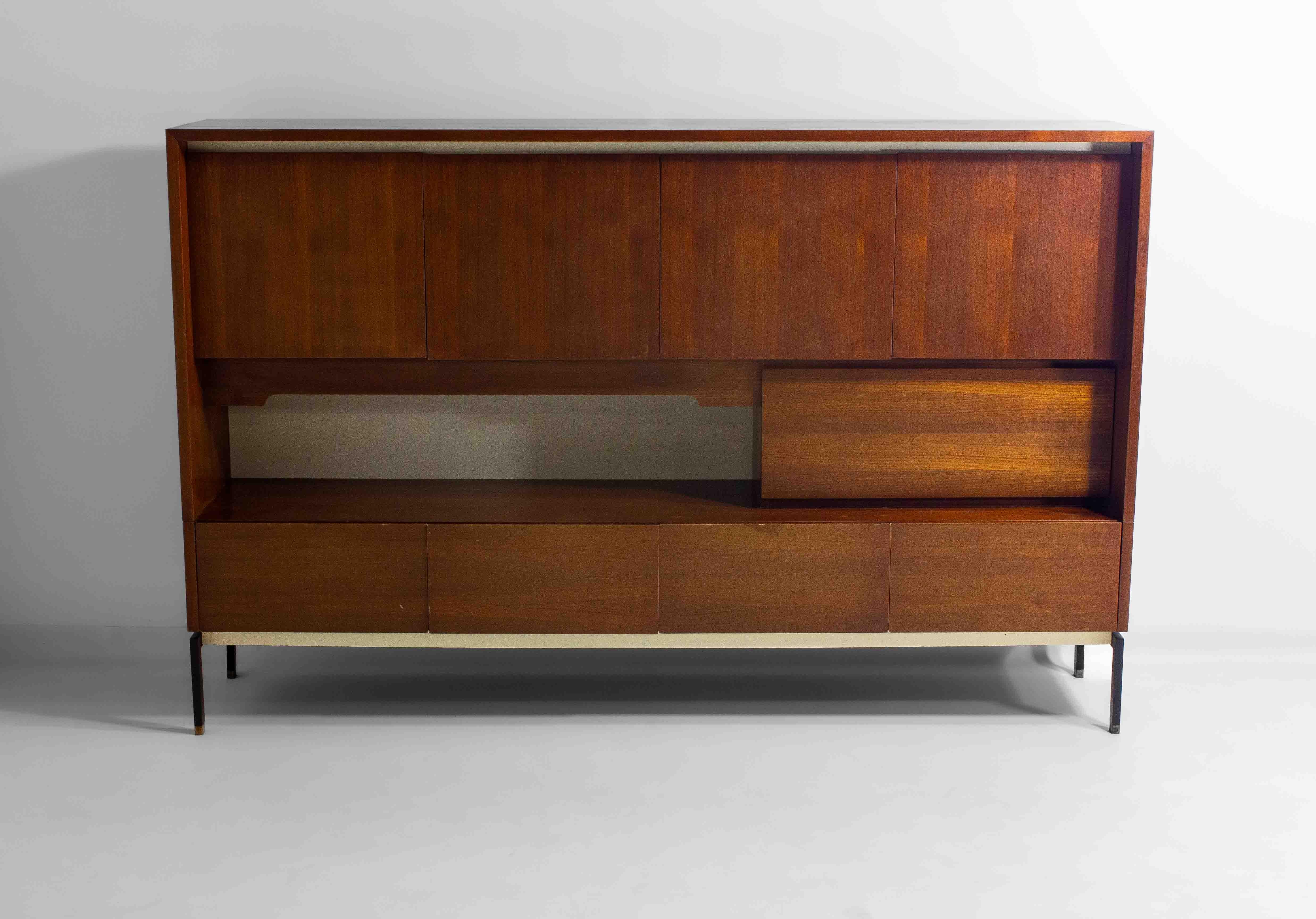 A large, yet minimalist mid-century modern storage cabine with the option to illuminate the middle section. The teak finish and clean lines make for an interesting play between sleekness and warmth.