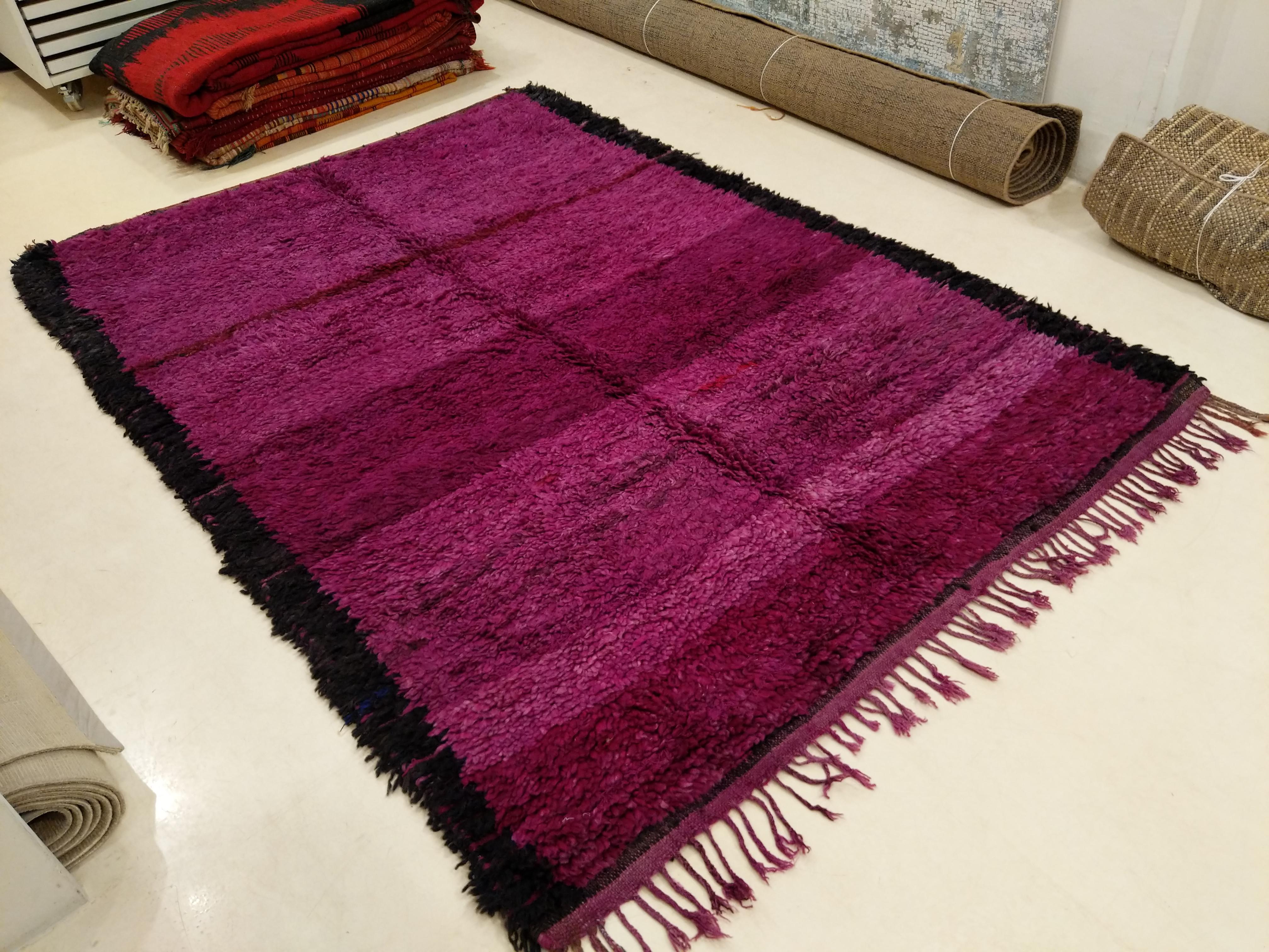 Open field Berber carpets make up a distinct group of weavings, originating from various regions of the Moroccan Middle Atlas and characterized by a plethora of tones of red. The present example is distinguished by a warm purple in a full range of