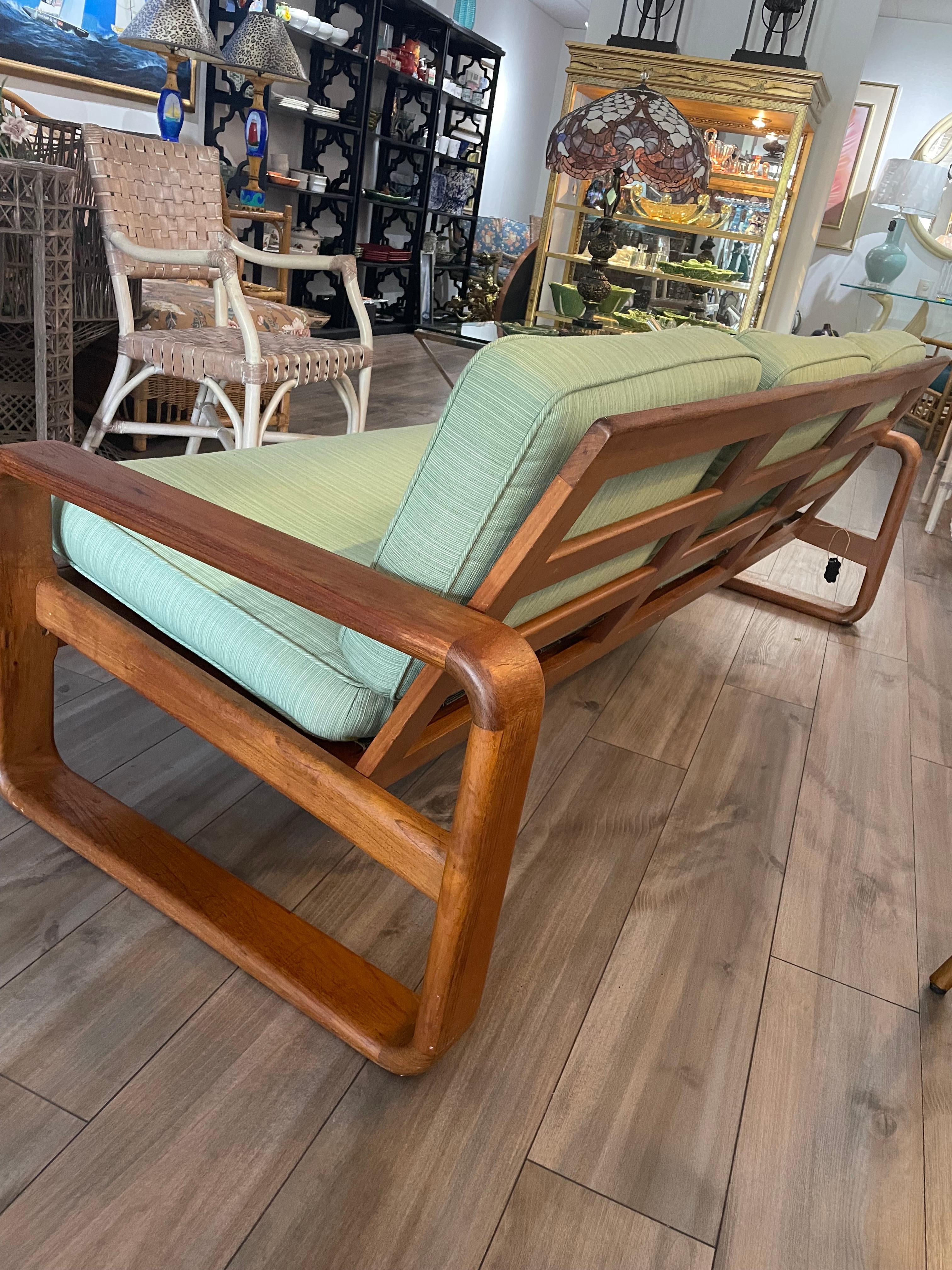 I believe this is 70;s Danish but has no markings, The teak is beautiful and in good condition. The lines on the profile are sleek and memorable. The cushion do not look original but in good condition, I could be wrong, the back of cushions are worn