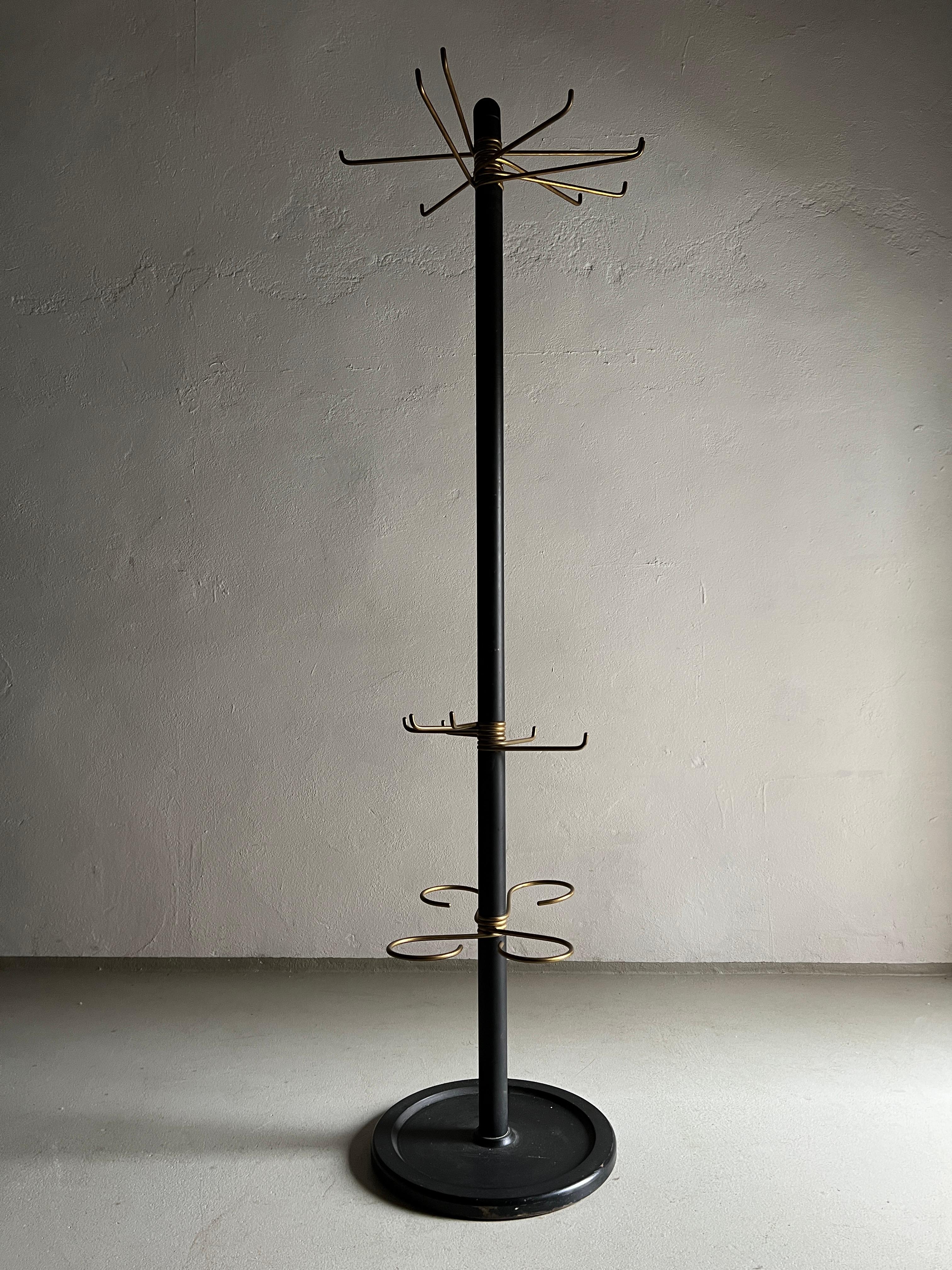 Vintage black metal coat stand made of a black painted iron base and brass details. Really heavy item.

Additional information:
Country of manufacture: Germany
Design period: 1940s
Dimensions: 174 H cm, D (base/upper):  40/53 cm 
Condition: Good