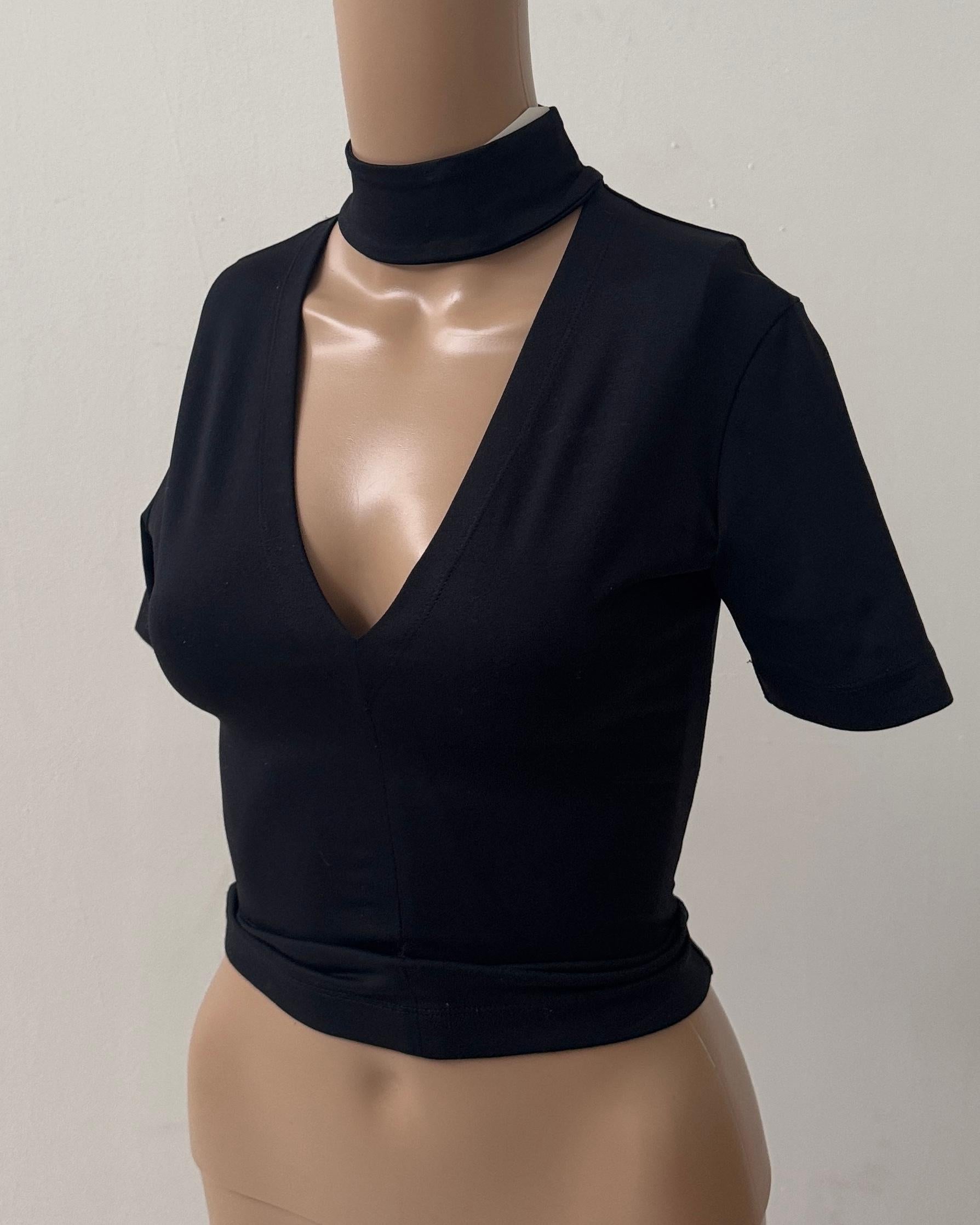 Striking and minimalist, this vintage black top by Plein Sud is a sleek example of '90s sensual tailoring. Made in France from a stretch fabric that hugs the figure beautifully, the piece features a deep V-neckline balanced by a built-in high choker