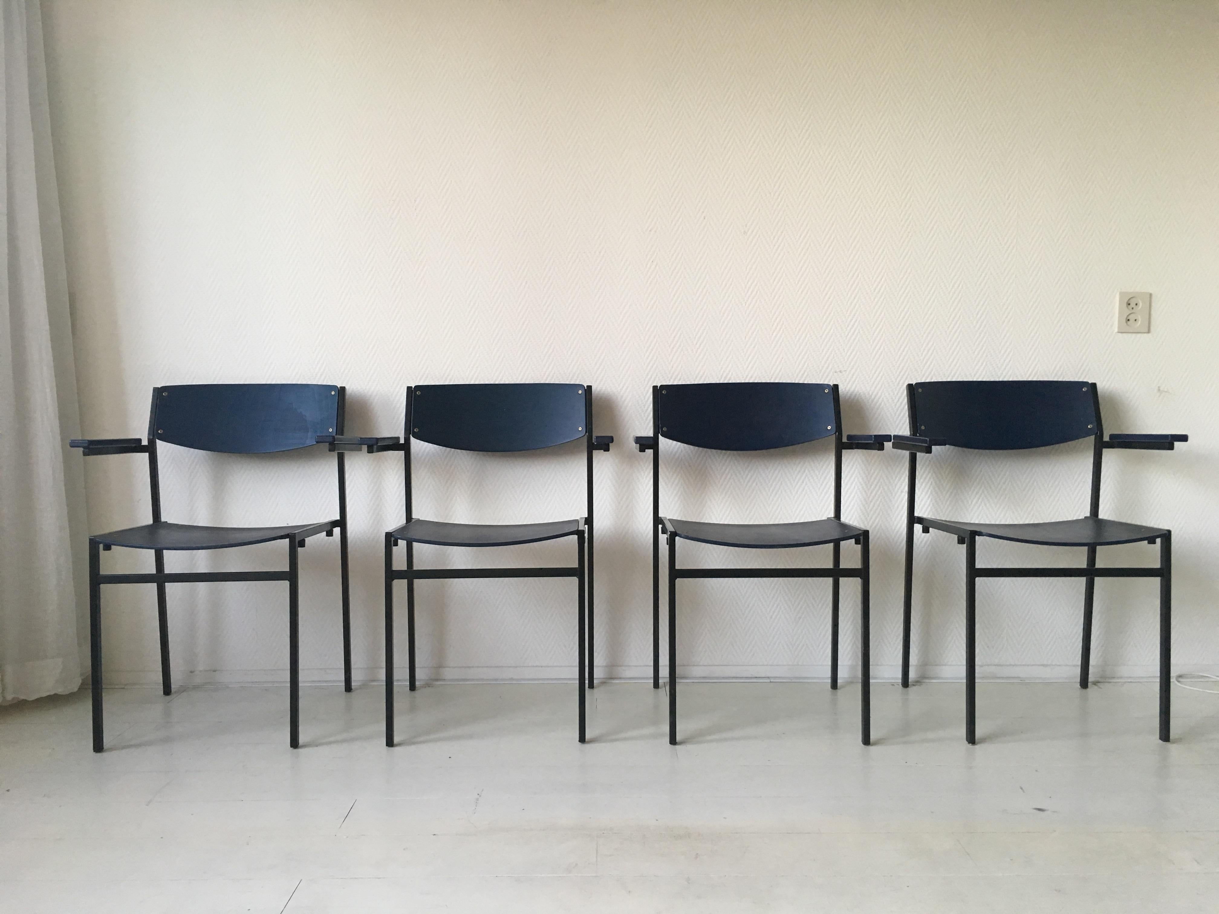 Cet ensemble de quatre fauteuils empilables de conception néerlandaise a été conçu par Gijs Van Der Sluis. Ils présentent une base en métal laqué noir et des assises et dossiers en contreplaqué bleu foncé. Des pièces multifonctionnelles (chaises