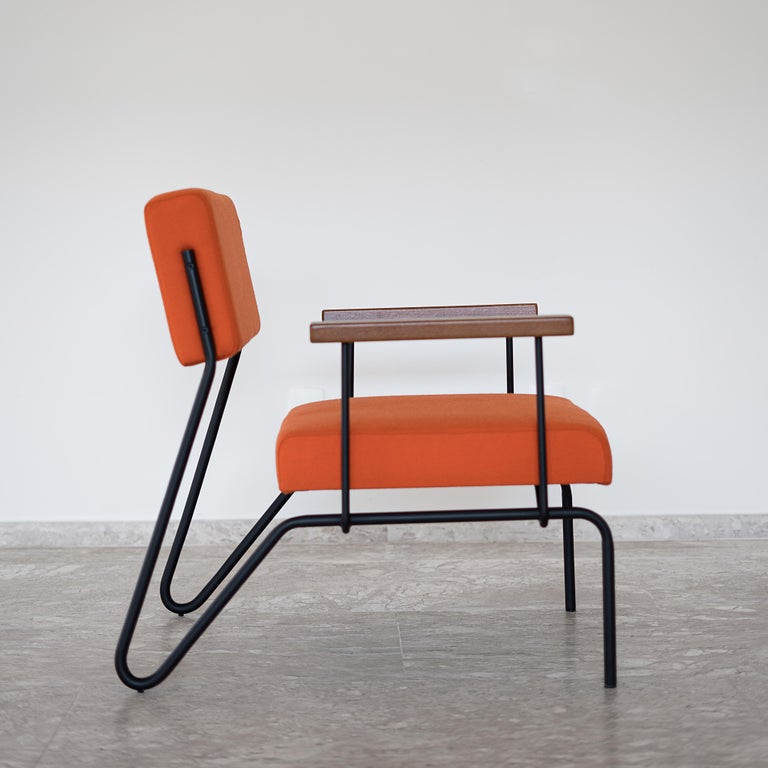This award winning minimalist armchair in steel, solid wood and leather is designed with a Classic and geometric reasoning. 
The continuity of the structural lines suggests fluidity. The backrest allows a smooth movement and just like the seat, it