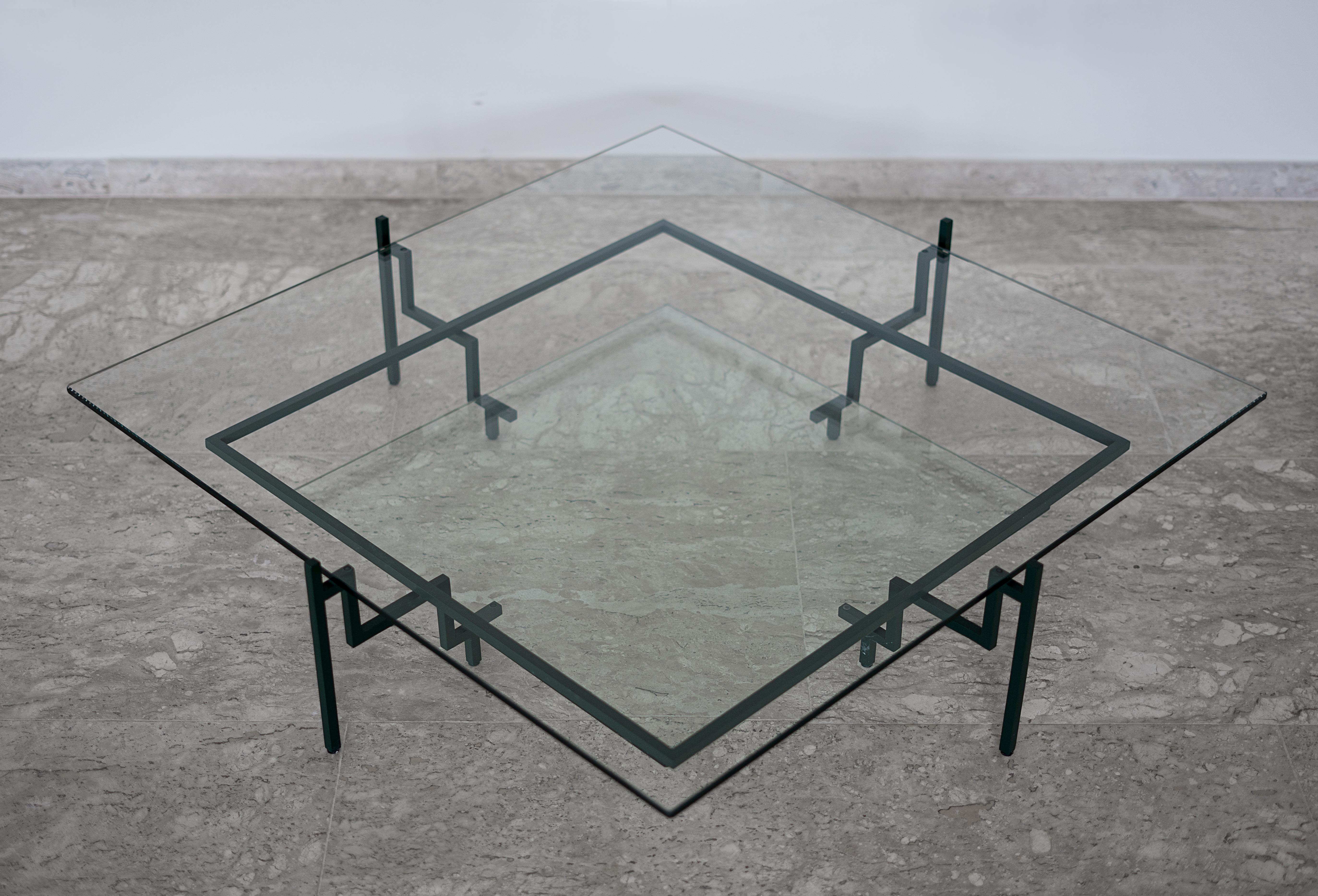 Cette table de présentation minimaliste en acier et en verre, qui a été primée, est conçue dans le cadre d'un raisonnement architectural et géométrique. Avec l'ADN carré, quatre supports en forme d'escalier sont reliés par une perle de hauteur
