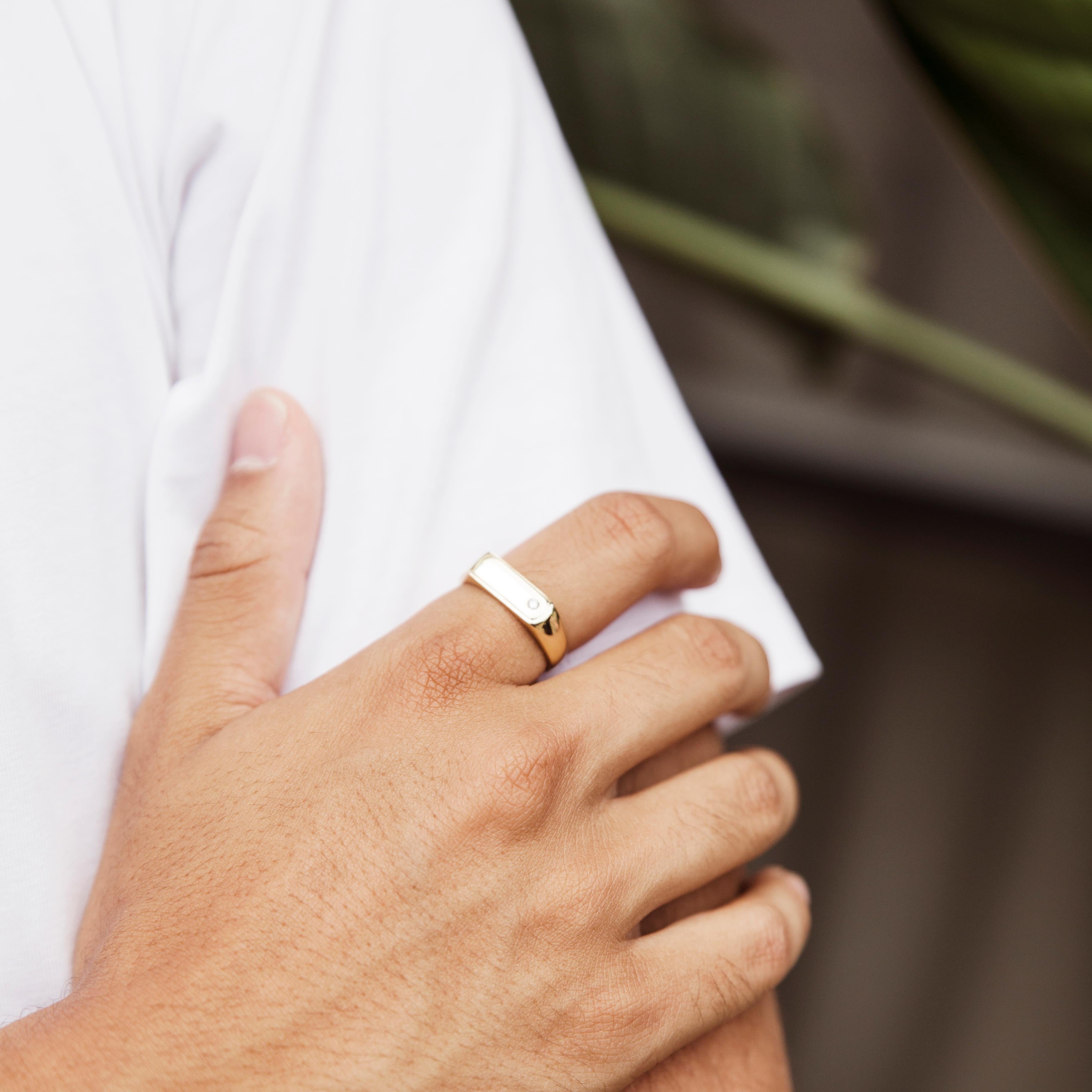 Forged in 9 carat yellow gold, this dapper men's signet ring features a high polish flat edge gold band rising up to a rectangular platform set with a single sparkling round brilliant cut diamond. This handsome piece, named The Han Ring, is one for