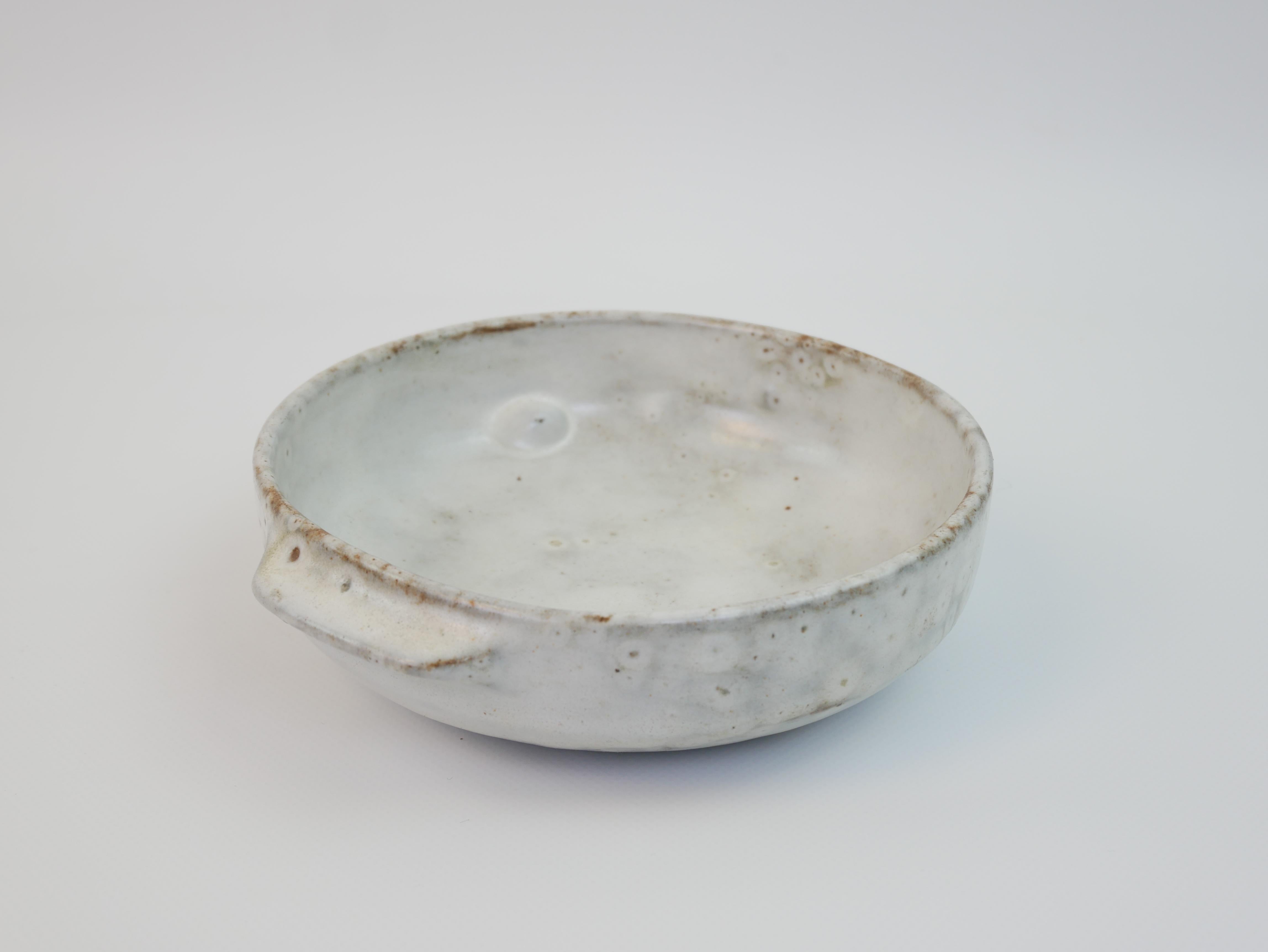 This minimalist ceramic dish or trinket holder was crafted by Alexandre Kostanda in Vallauris during the 1950s. Known for his refined, organic forms and textured finishes, Kostanda’s work embodies the post-war modernist aesthetic. The dish features