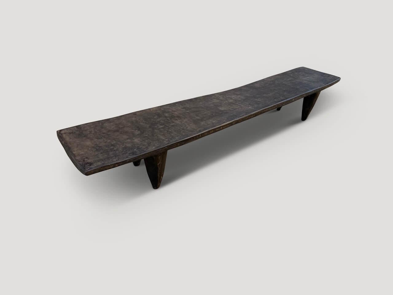 Beautiful narrow coffee table or bench hand carved from a single block of wood from Guinea. The wood is tough, dense and very durable. Shown with carved cone style legs. We only source the best. This one is a beauty. Circa 1950

This coffee table or