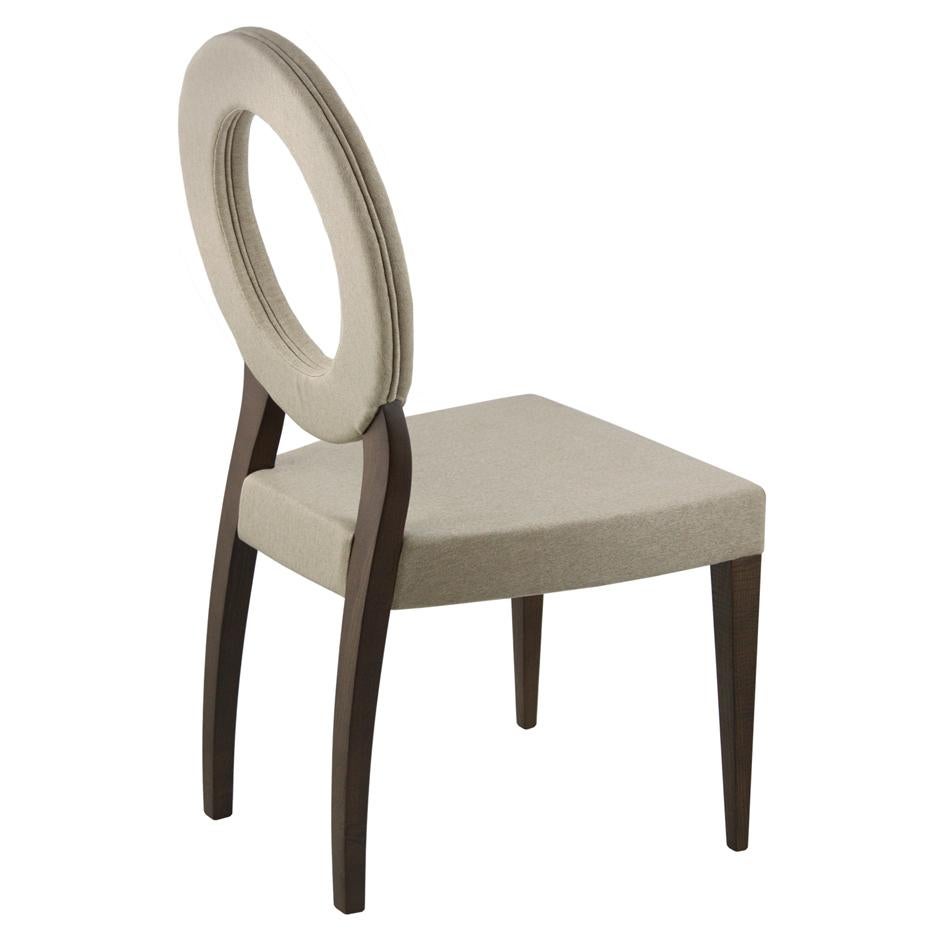 This chair is a striking piece with a contemporary and luxurious design. It features a plush, deep blue velvet upholstery on both its circular backrest and comfortable square seat. The backrest is particularly distinctive, forming a large, open ring