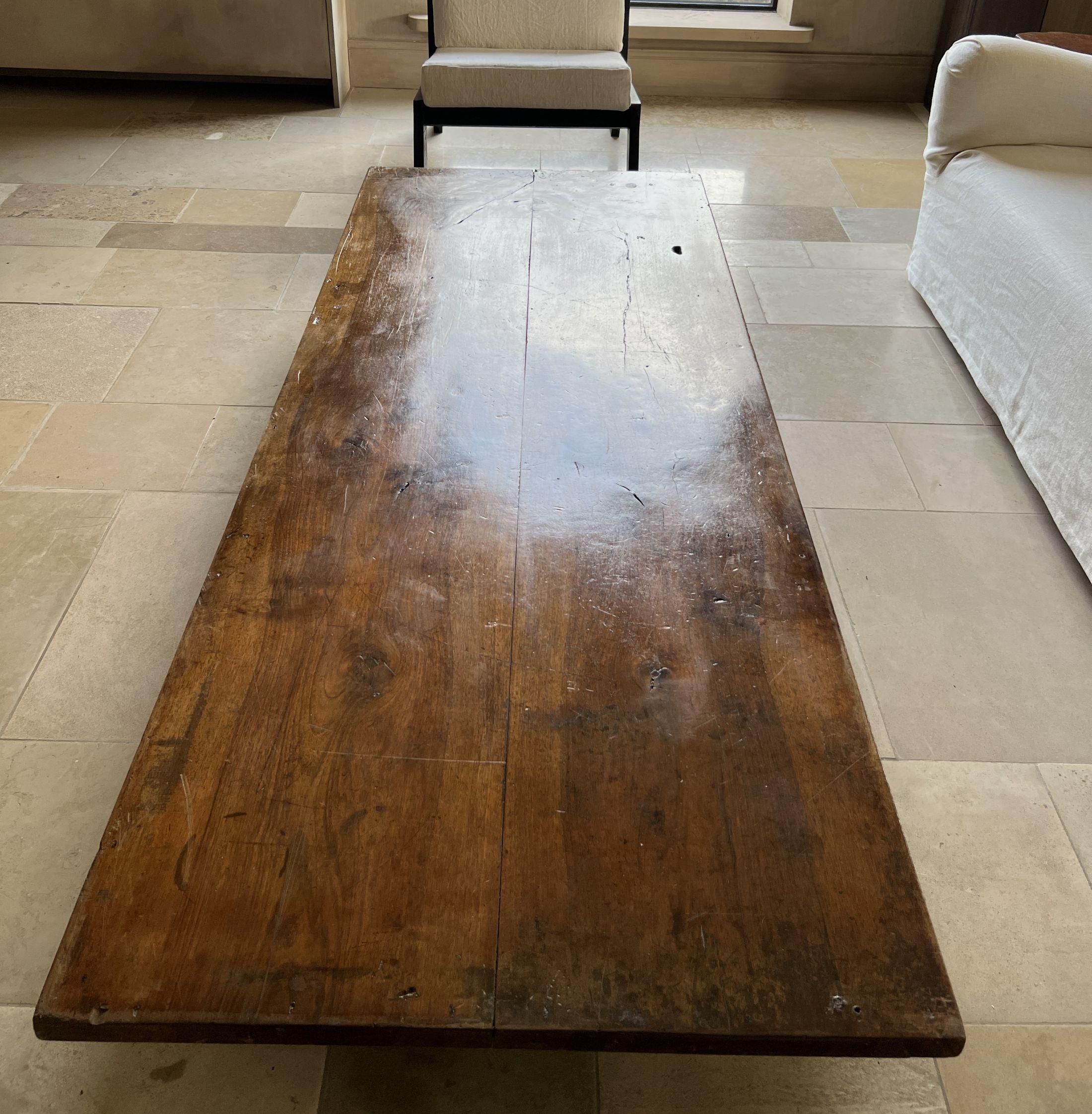 Table basse fabriquée par notre atelier à partir d'un plateau en noyer italien du 19ème siècle et de bases en fer.