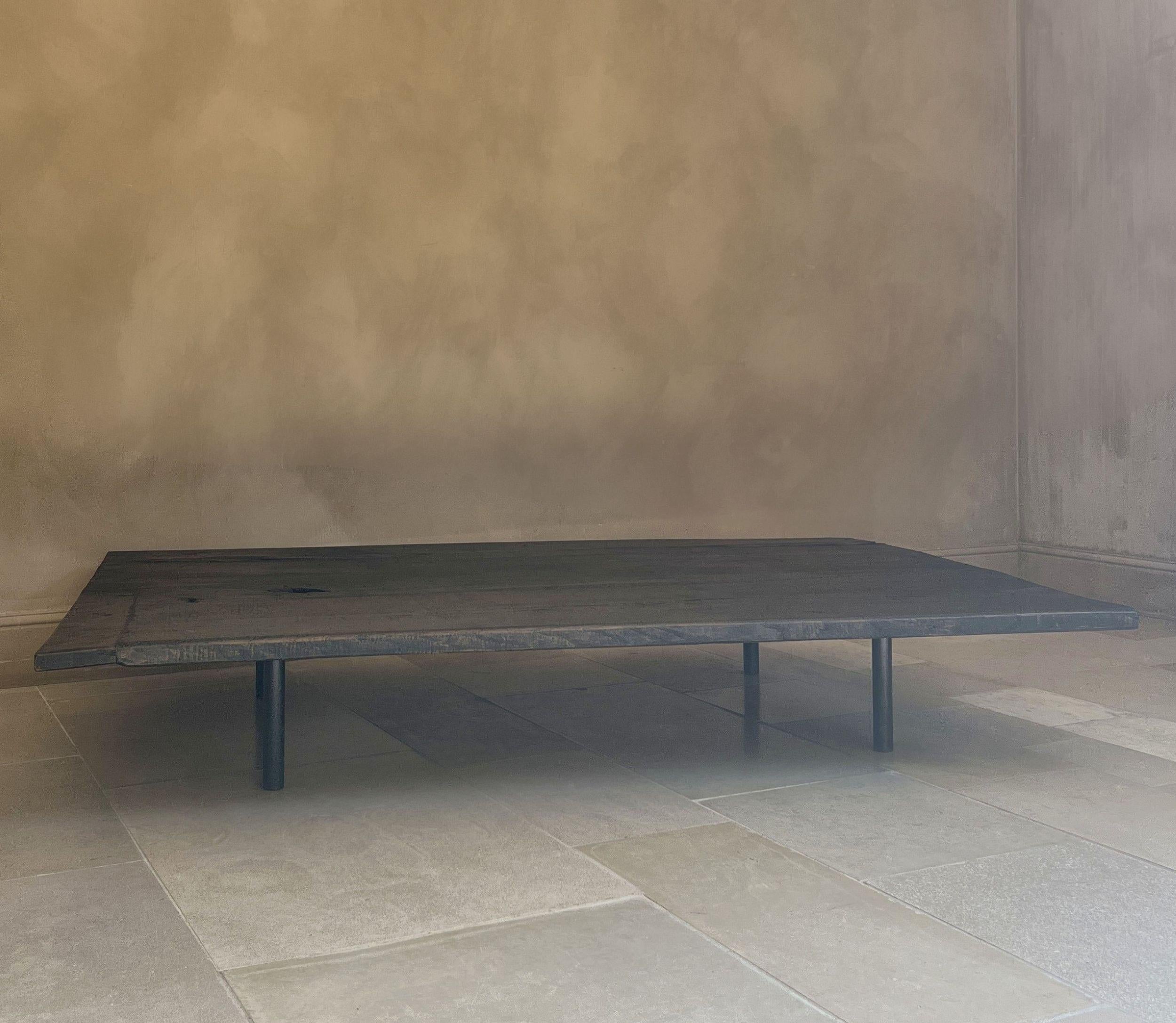 A minimalist coffeetable made in our workshop from a set of 3 matching 18th century Portugese walnut slabs. Mounted on custom iron feet. Great color, structure and patina. The wood giving warmth to the basic design with lots of attention to