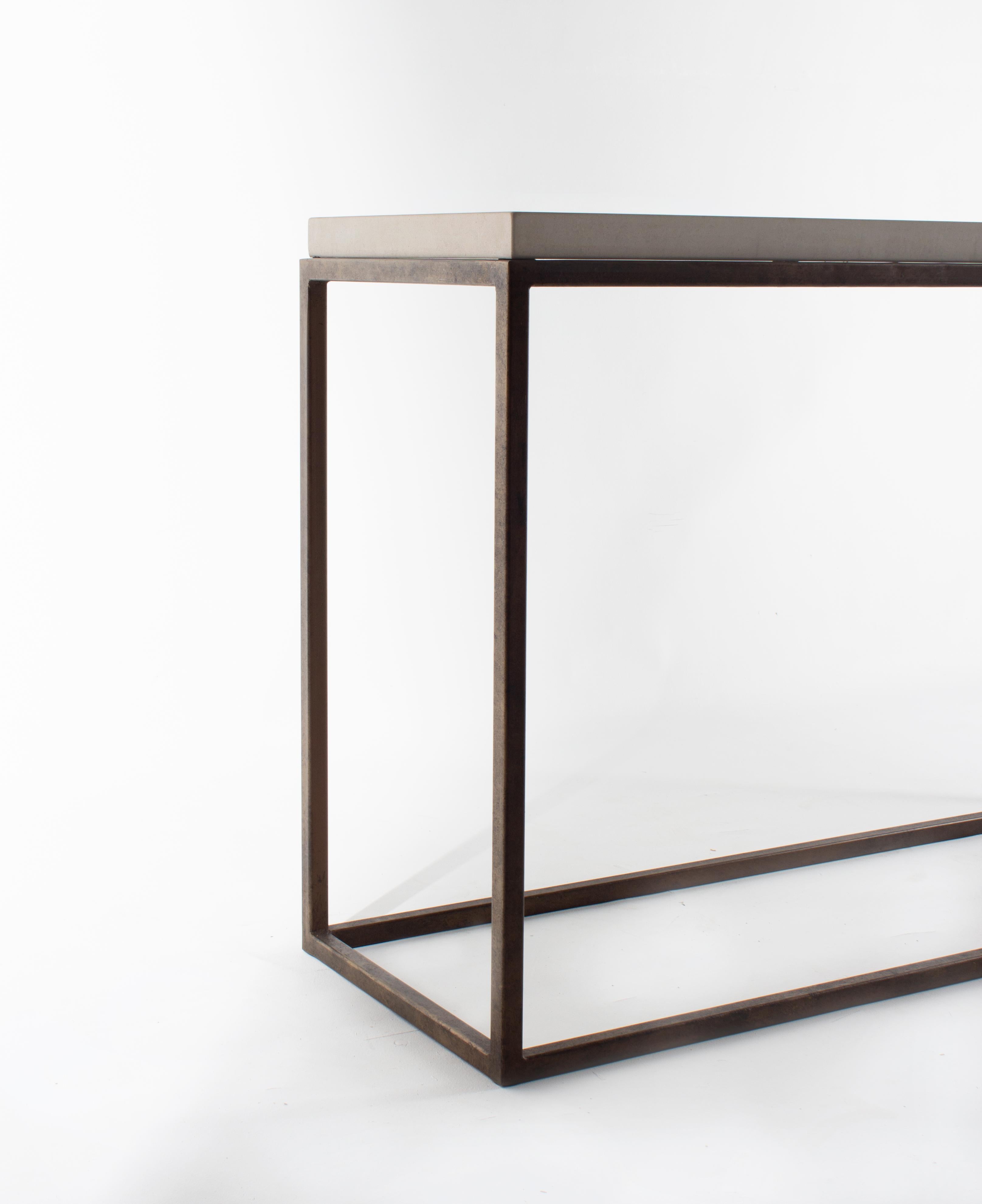 Minimalist console table with a limestone top and steel base.