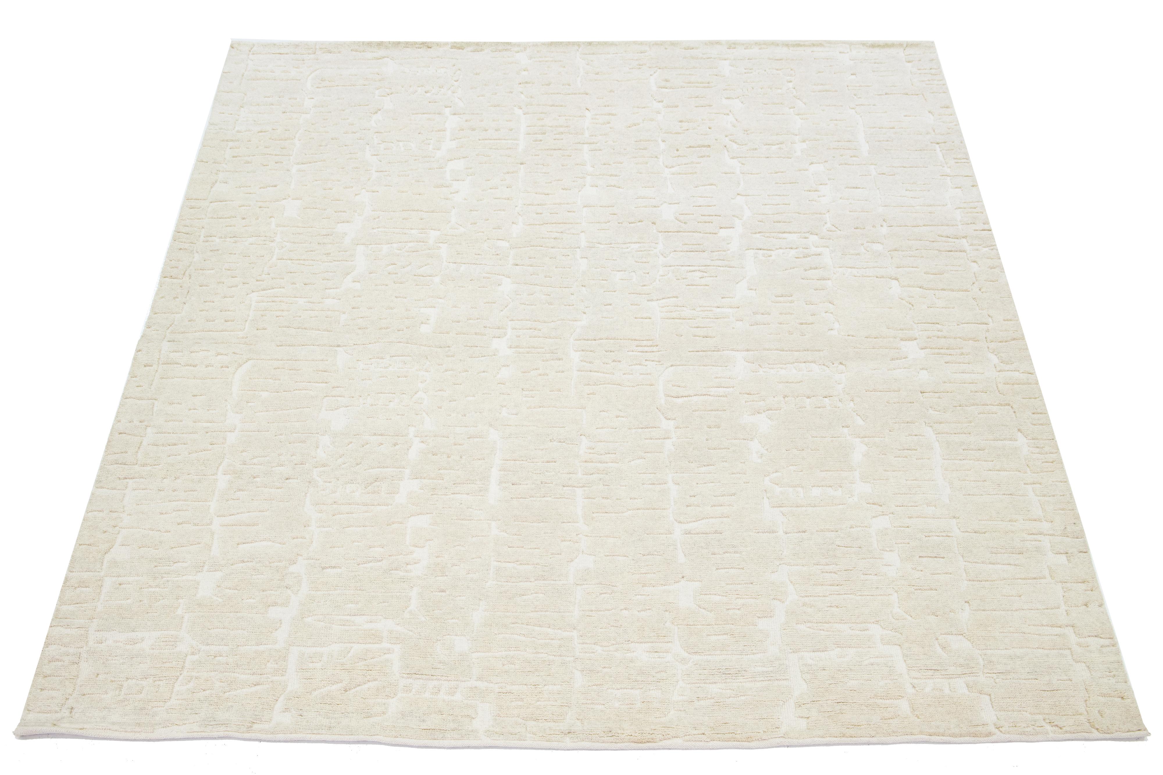 This hand-knotted Moroccan-style wool rug showcases a mesmerizing minimalist aesthetic on a natural ivory field with a contemporary design.

This rug measures 8'1
