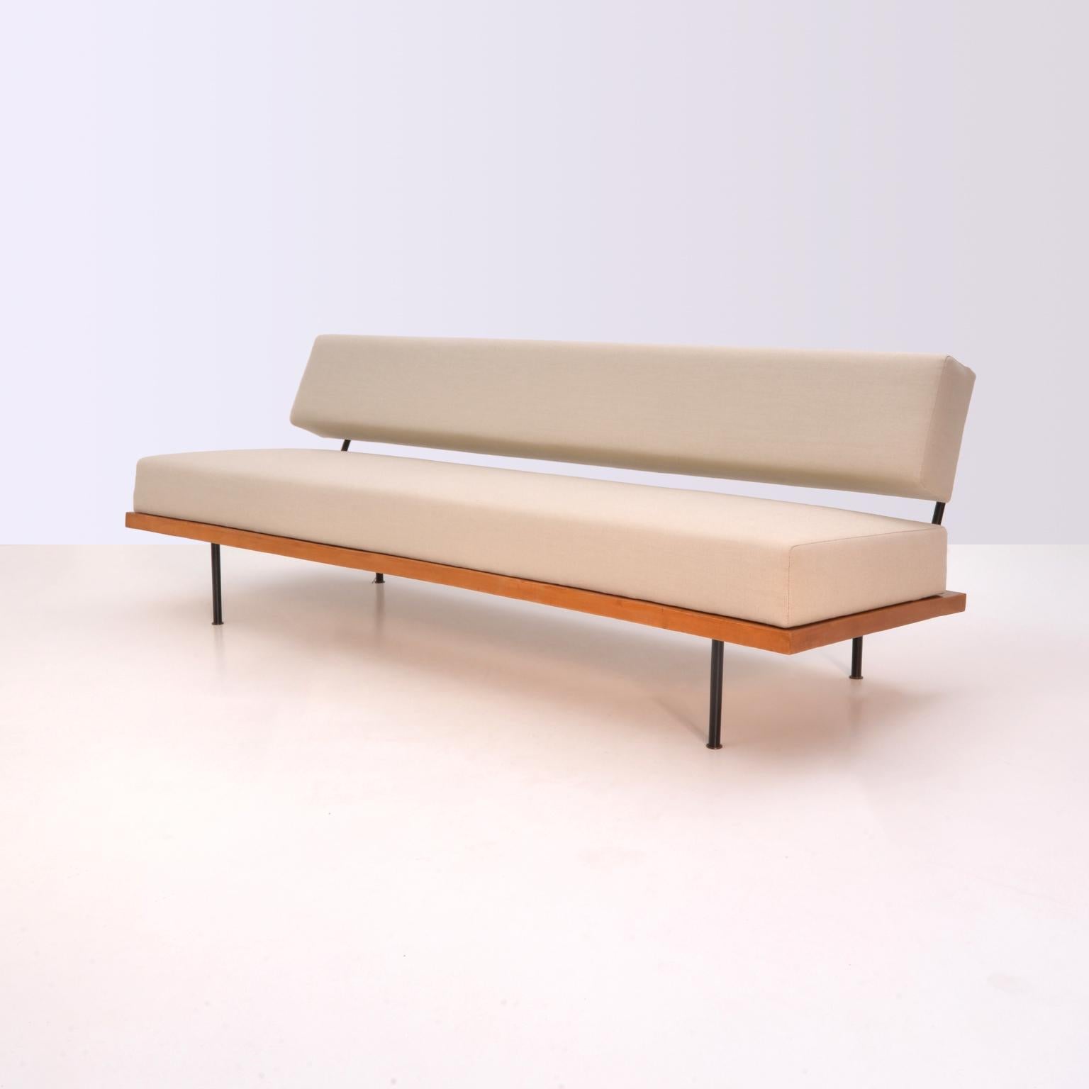 Minimalist Florence Knoll couch/daybed, manufactured by Knoll International, Stuttgart, Germany, circa 1960. The essential light structure consists of a cherrywood frame held on black painted tubular steel legs. The swivel backrest is held by black