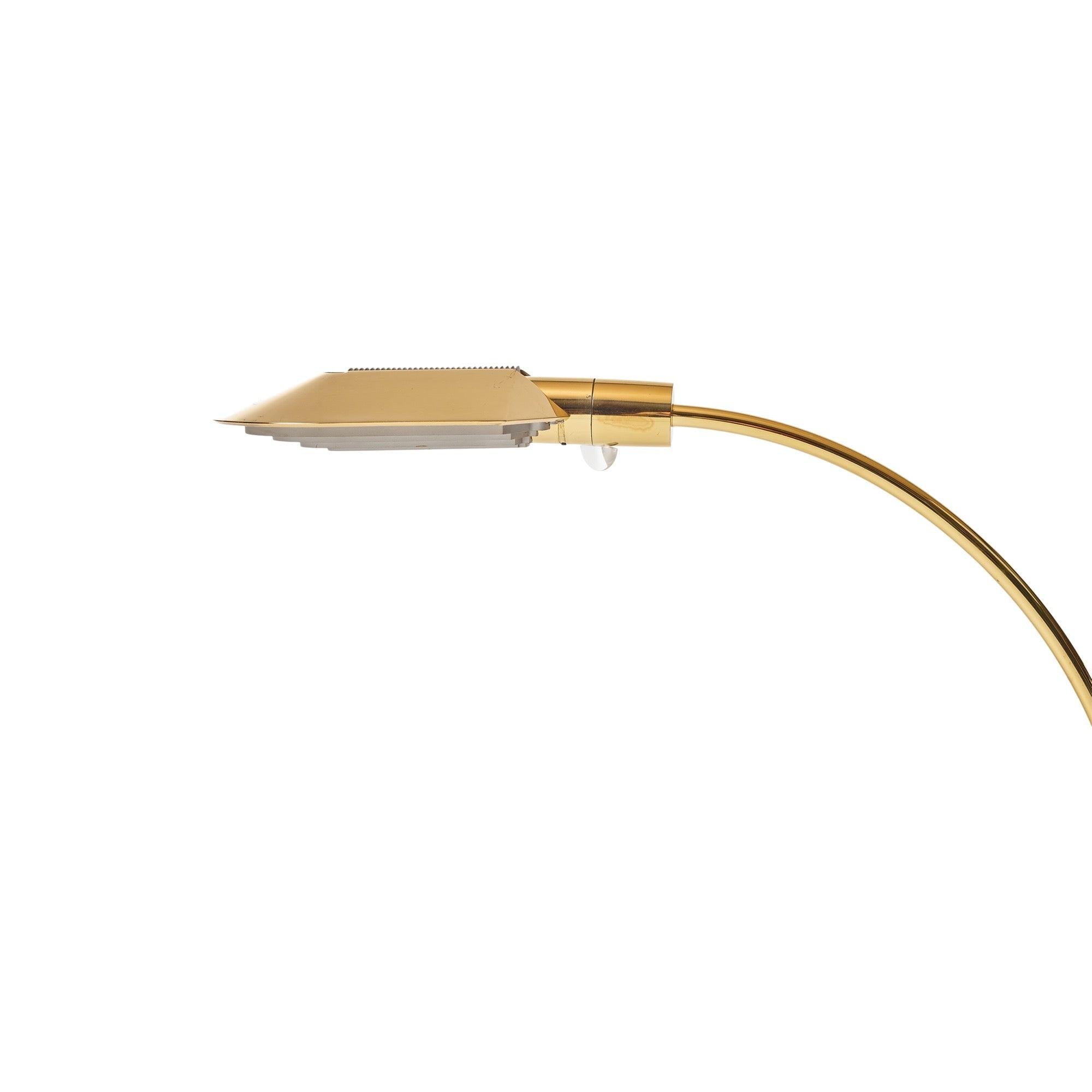 Lampe de bureau en laiton à contrepoids, avec un abat-jour arrondi et un bras en laiton incurvé. La lampe pivote sur sa base en nylon, parfaitement lestée, elle tourne sur ce point.