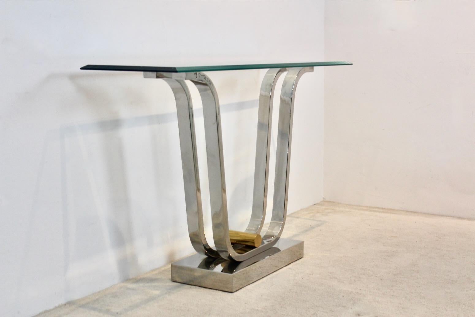 Wunderschöner und minimalistischer Konsolentisch, entworfen in Deutschland. Die Konsole besteht aus einer charakteristischen Kombination von poliertem Edelstahl und Messing mit Glas. Bestehend aus einem geschwungenen Sockel aus poliertem Edelstahl