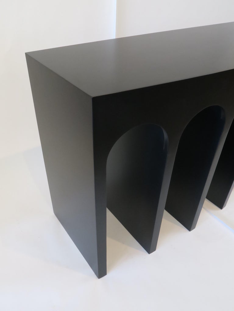 Martin and Brockett's Arcade console is a nod to the ancient Roman architectural form- a succession of contiguous arches supported by columns. The console has a slight convex curvature at the face. Shown in our black satin lacquer. 

Part of our