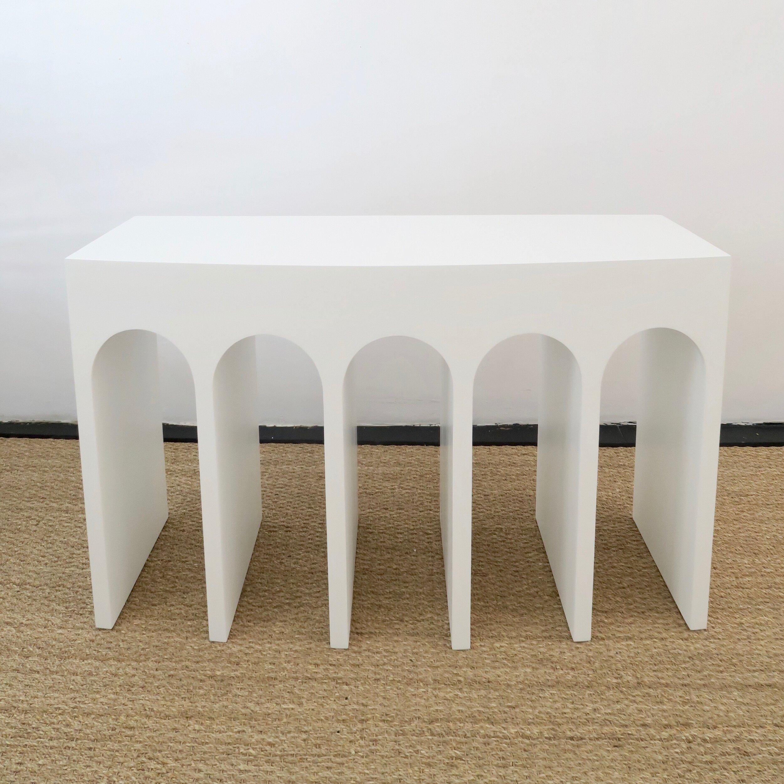 Martin & Brockett's Arcade Console 48” is a nod to the ancient Roman architectural form- a succession of contiguous arches supported by columns. It features a slight convex curvature at the face and a textured surface. Shown in White Porcelain