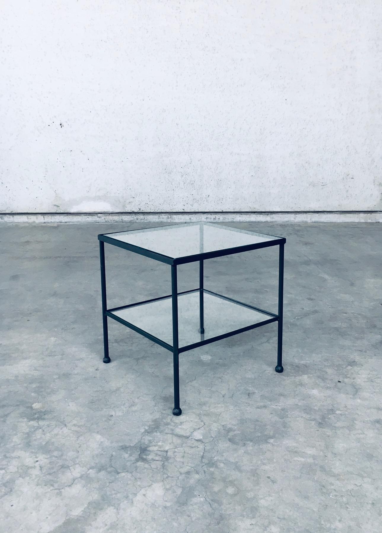 Table d'appoint basse à deux niveaux au design minimaliste. Fabriqué en Belgique, période des années 1960. Table d'appoint, table de chevet ou bout de canapé. Elle est fabriquée à la main en acier laqué noir avec des incrustations en verre