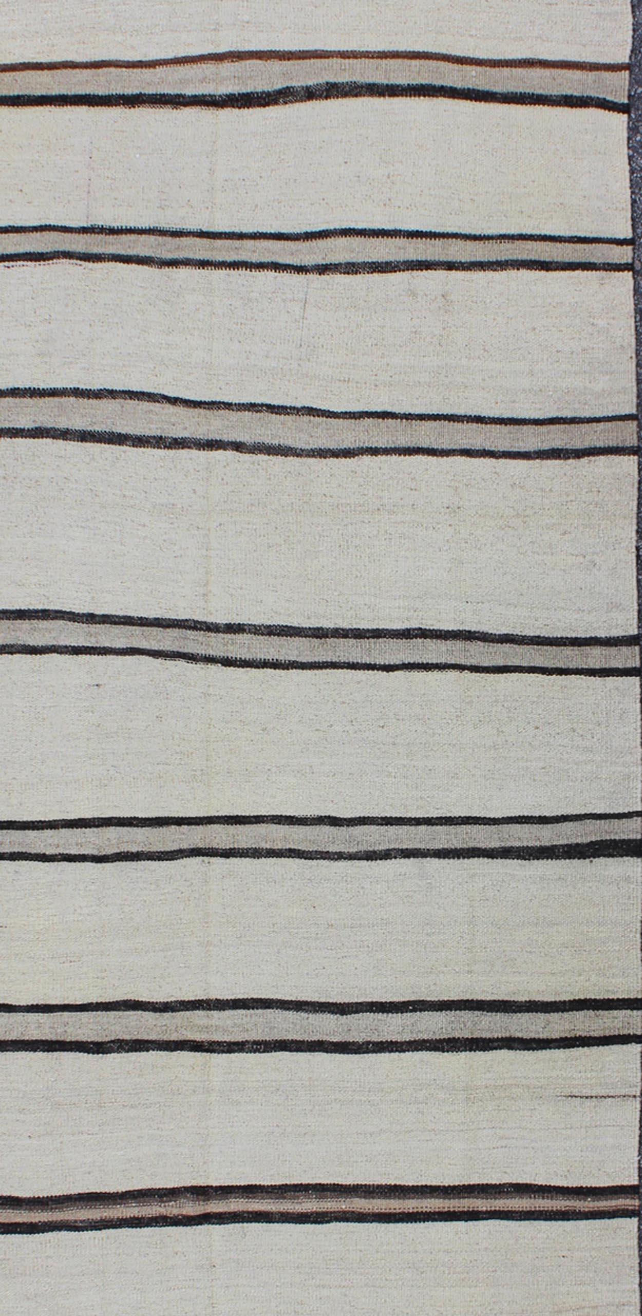 Minimalist design with traces of stripes Kilim runner in cream, light brown and taupe, rug EN-165689, country of origin / type: Turkey / Kilim, circa 1950

This flat-woven Kilim runner from Turkey features an understated composition consisting of