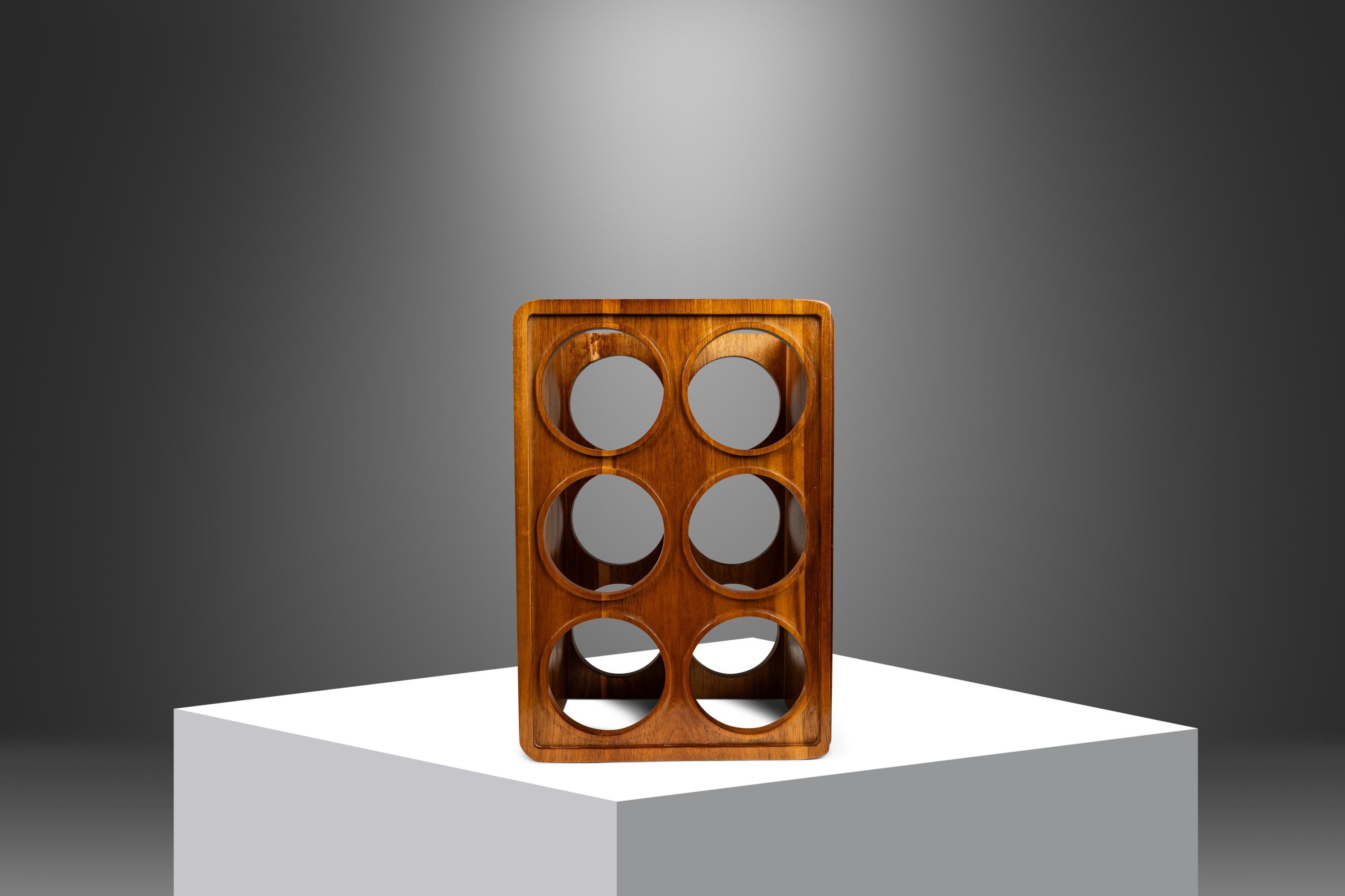  Introducing an artfully-crafted wine rack hand-crafted from solid slabs of monkey pod wood. Ultra-minimalist in it's stance and utility this versatile rack can be used both in vertical or horizontal positions. Featuring out-of-this-world variegated
