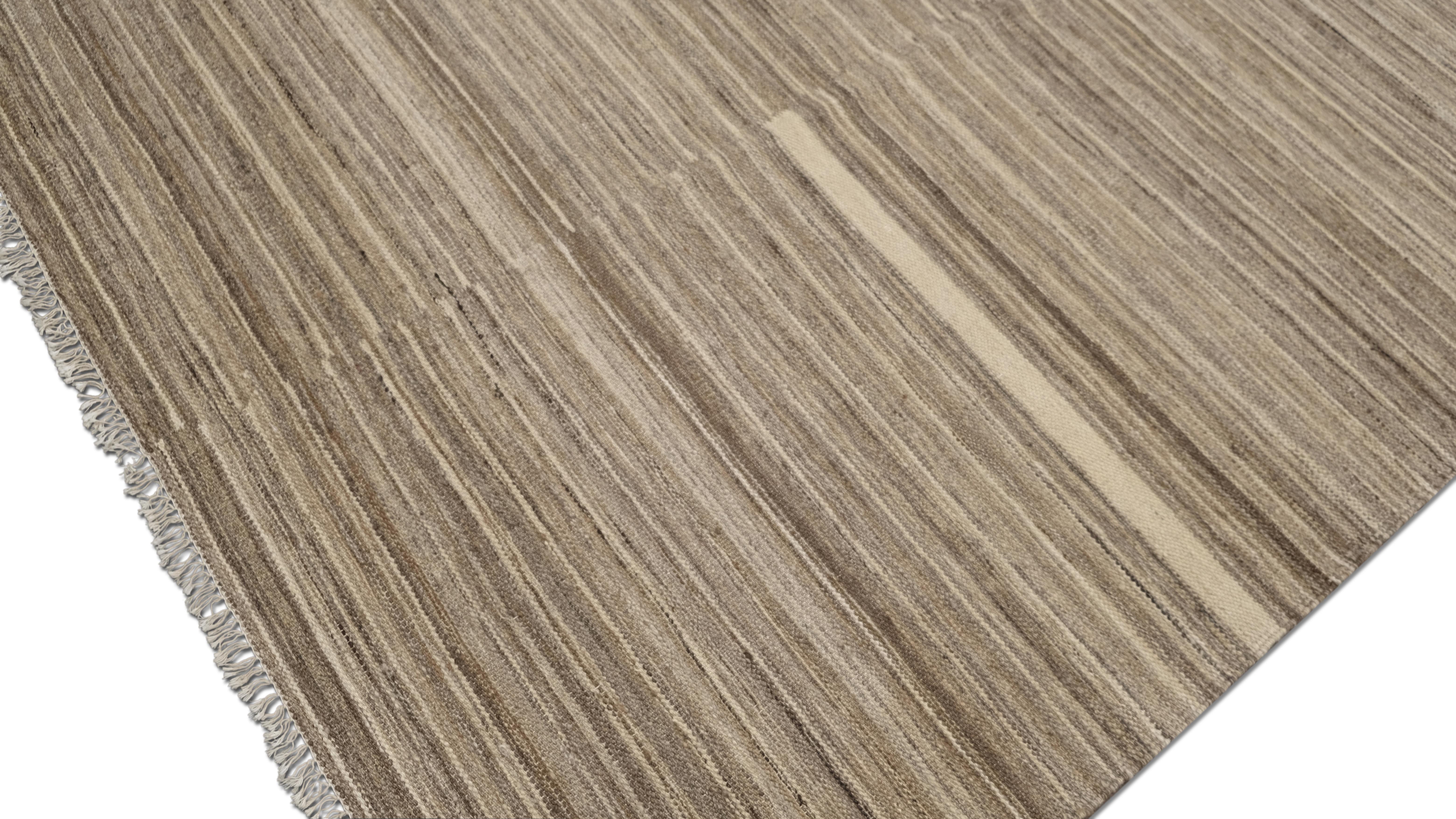 Dieser exquisite, handgewebte Wollteppich verkörpert moderne Schlichtheit mit einer geometrischen Note. Dieses aus handgesponnener Wolle gefertigte Stück weist ein elegantes Muster auf, das durch Variationen der natürlichen Wolltöne entsteht und