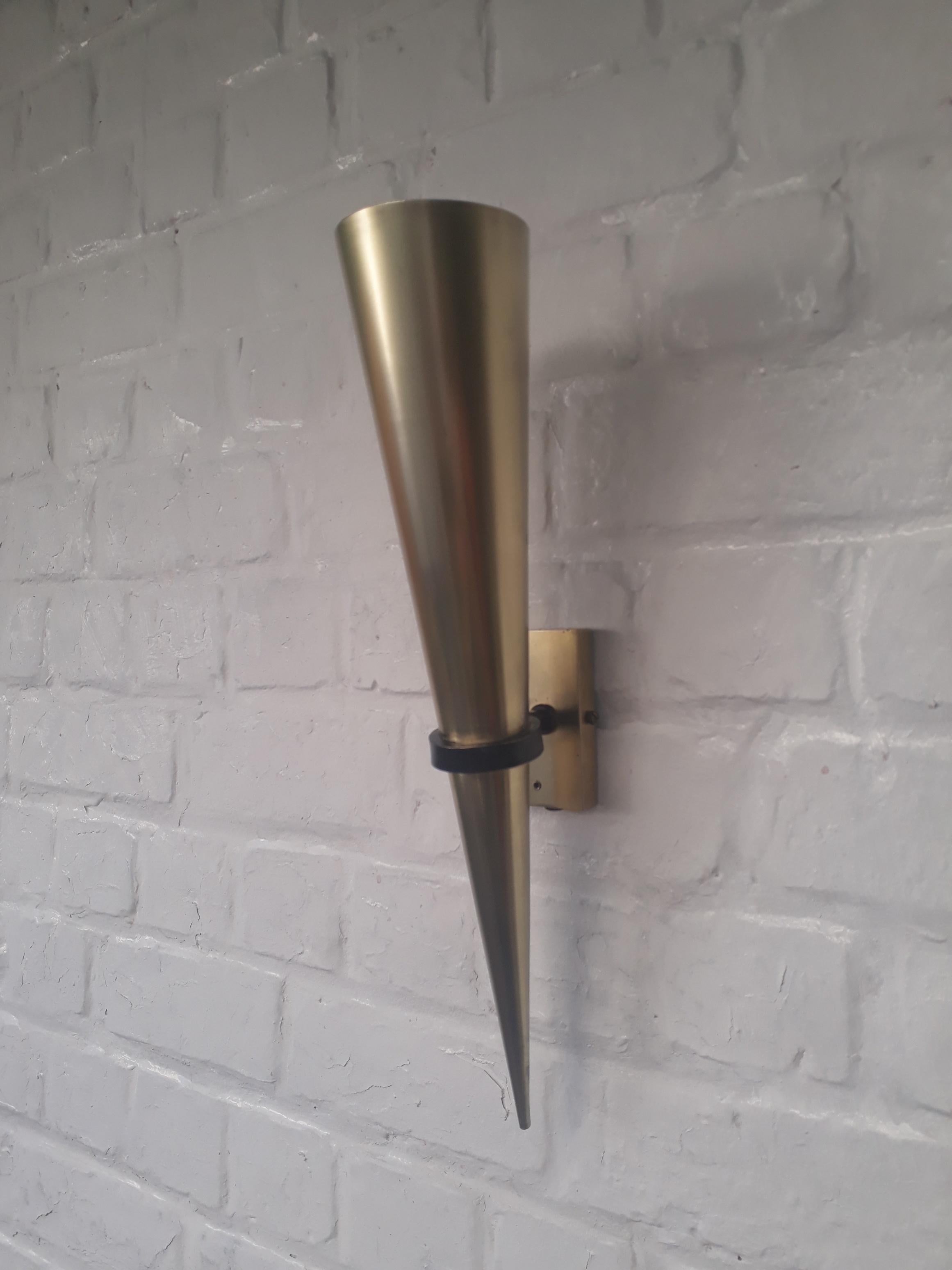 Midcentury wall sconce in full brass with a black painted ringlet holding the cone shaped diffuser. It has a terrific minimalist look. Two small holes were drilled in the front plate.