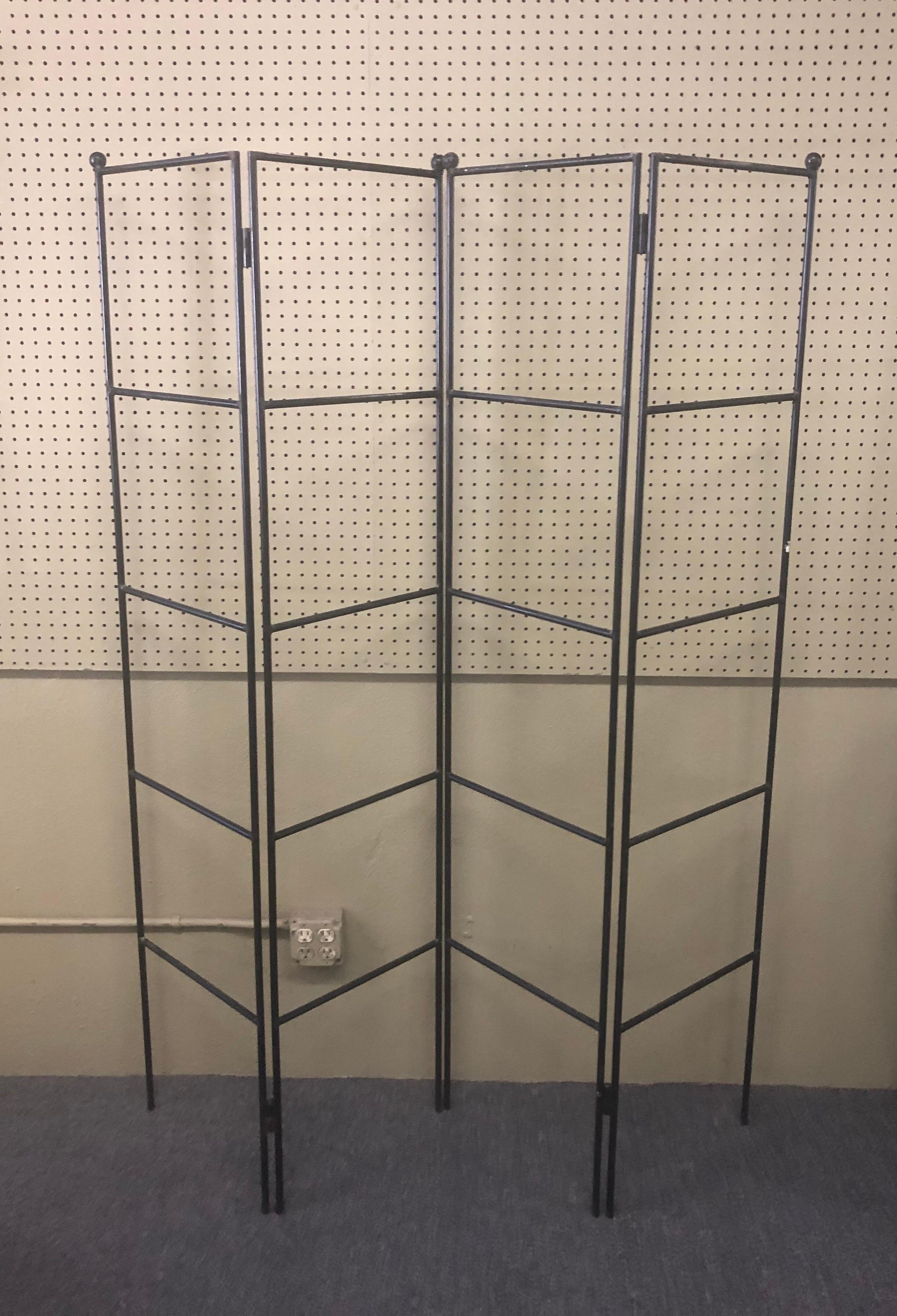 A very cool and simple Minimalist four-panel wrought iron room divider / screen, circa 1970s. The screen is split into two pieces with two panels each and can be used separately or together. Each panel is 16