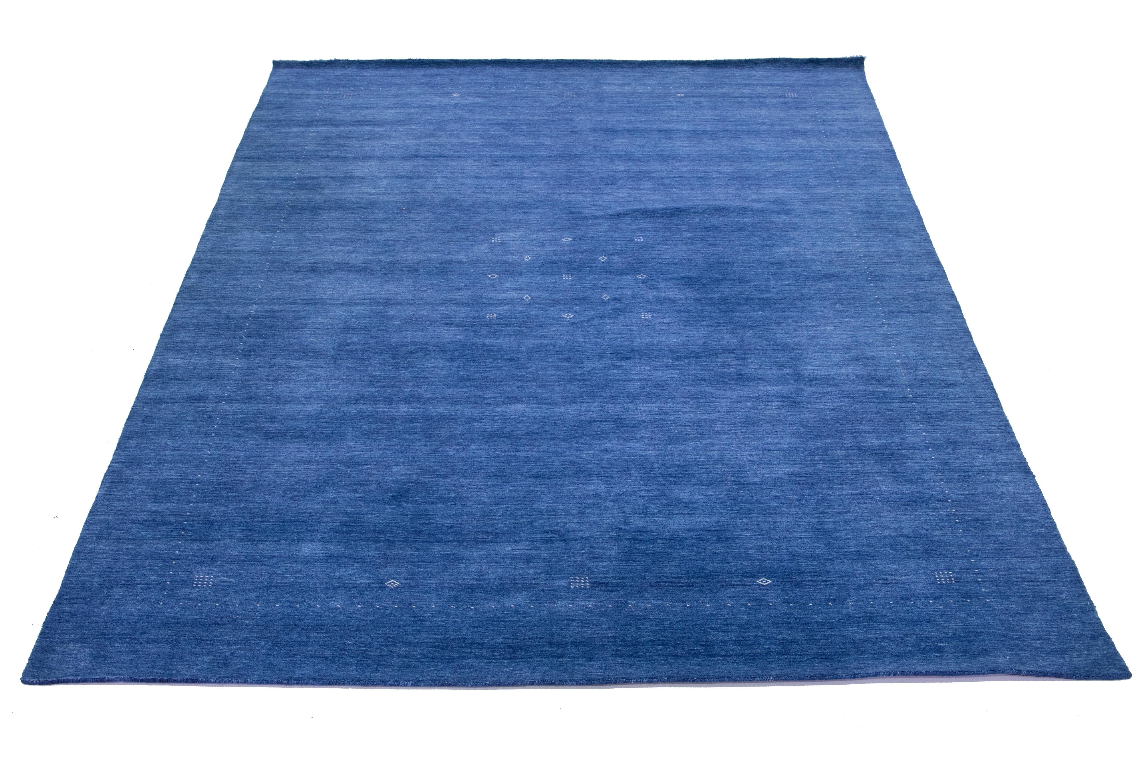Beautiful modern Gabbeh-style hand-woven wool rug with a navy blue color field and gorgeous white minimalist design.

This rug measures: 9'10
