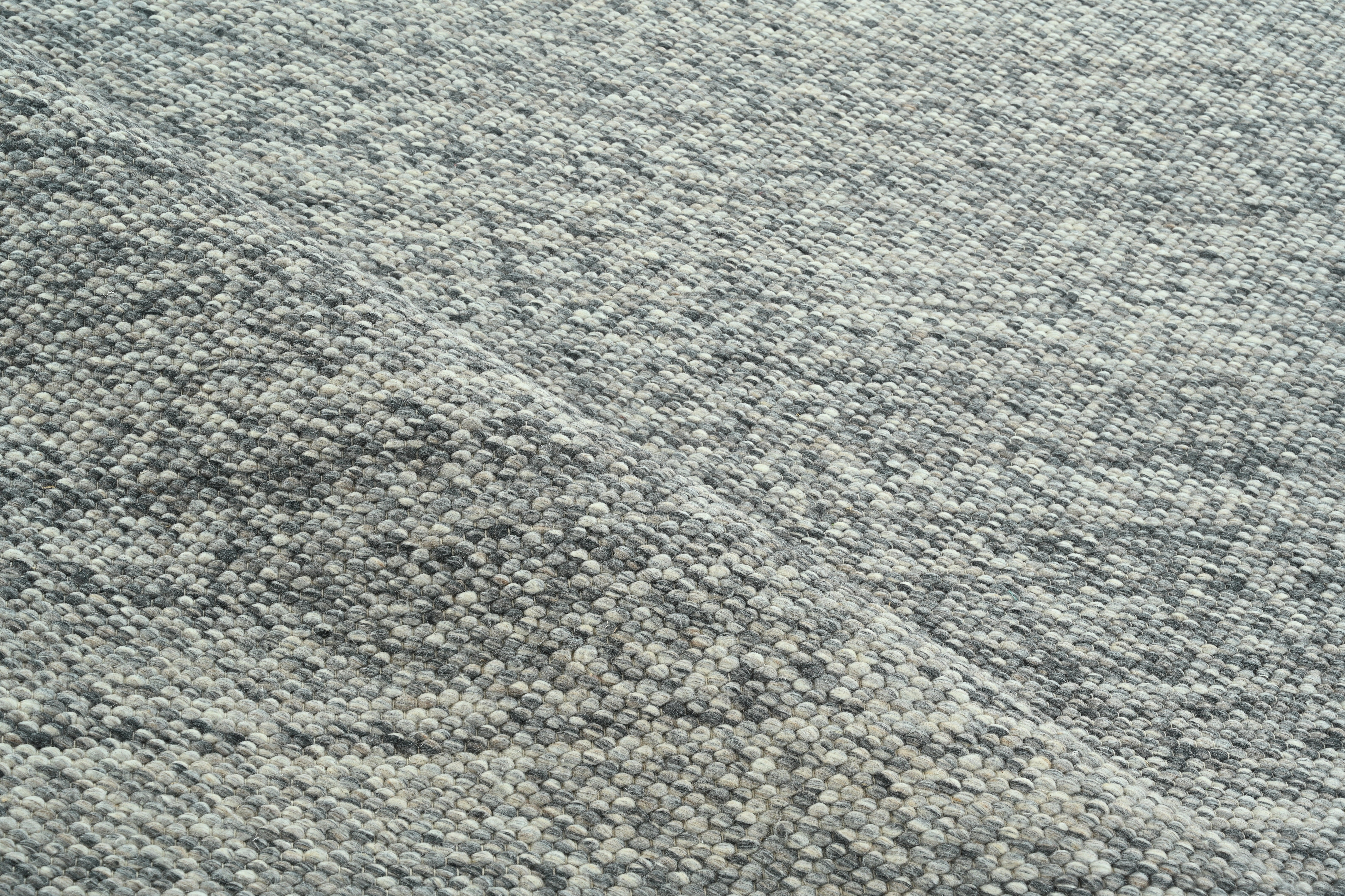 Tappeto minimalista in lana fatto a mano di colore grigio tenue, design contemporaneo e strutturato