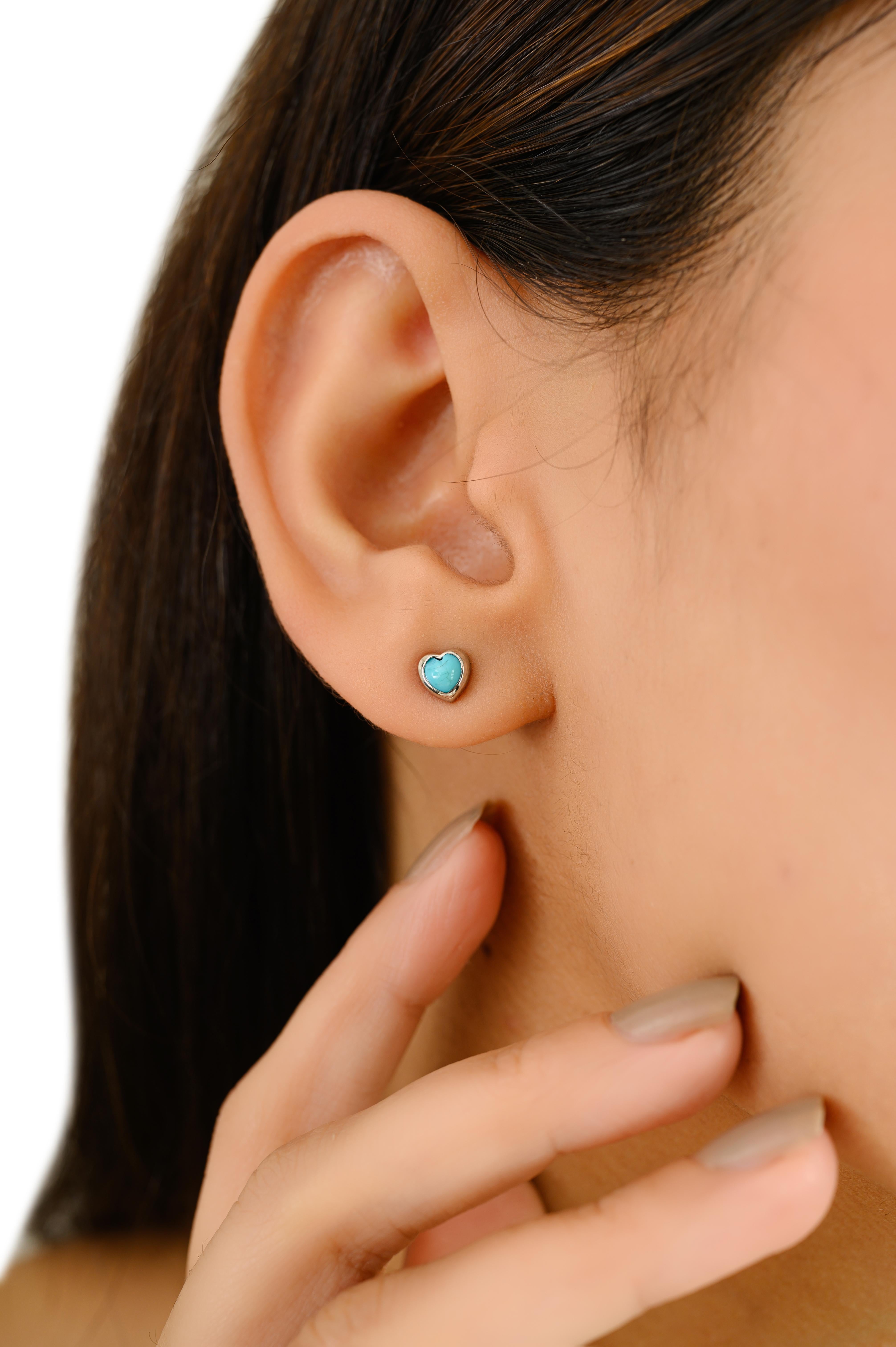 Charming and contemporary, these 14k white gold stud earrings feature heart-shaped turquoise cabochons with a total stone weight of 0.49 carats. Set in a sleek bezel frame, the natural sky-blue turquoise stones radiate warmth and playful elegance.