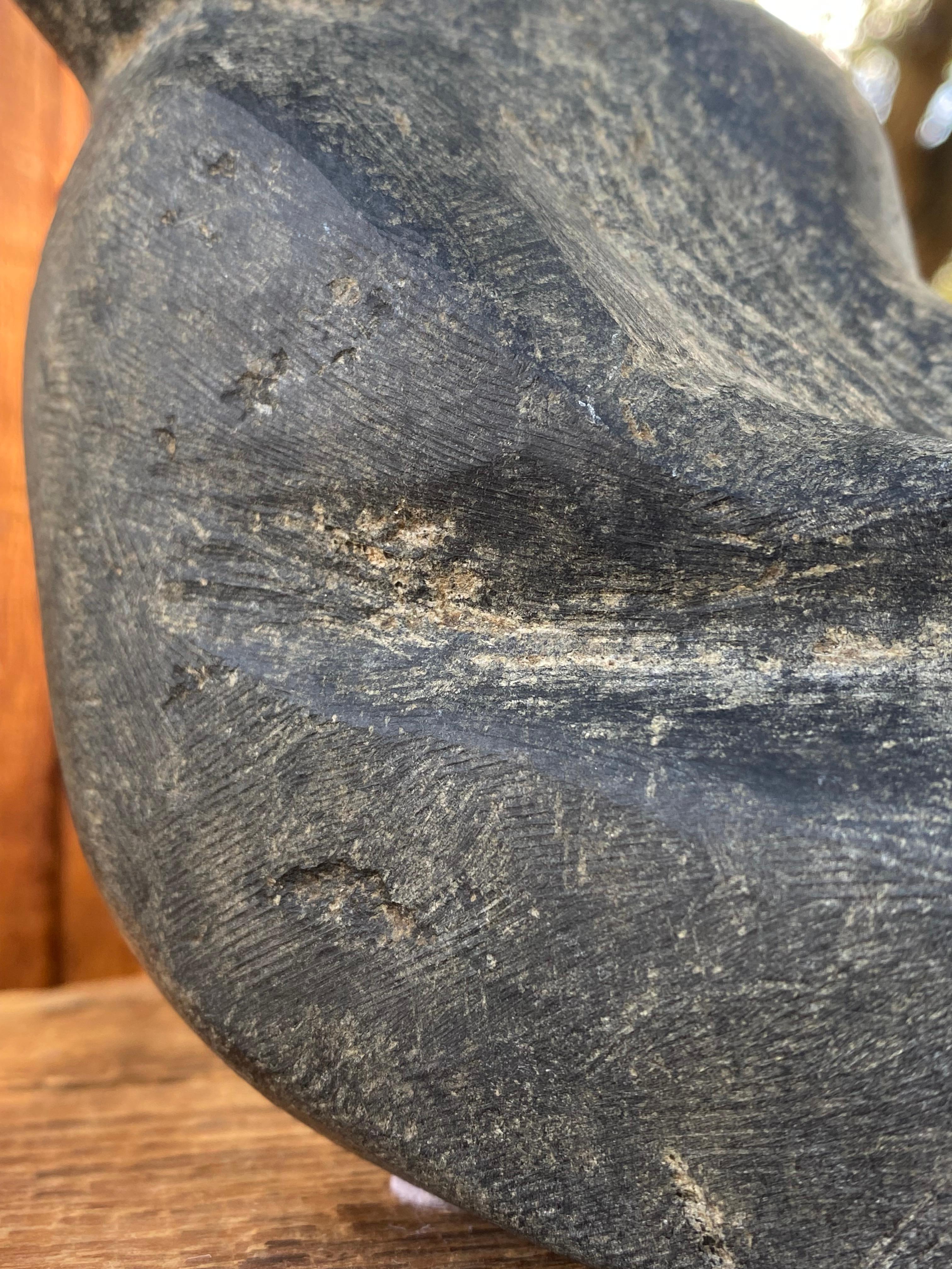 A fine early Inuit sculpture from the remote Arctic village of Eskimo Point, also known as Arviat, depicting a seated and leaning figure. A very lively expressive carving.

We attribute this piece to Marc Alikaswa:

Marc Alikaswa ᒪ ᐃᓕᑲᓱᐊ