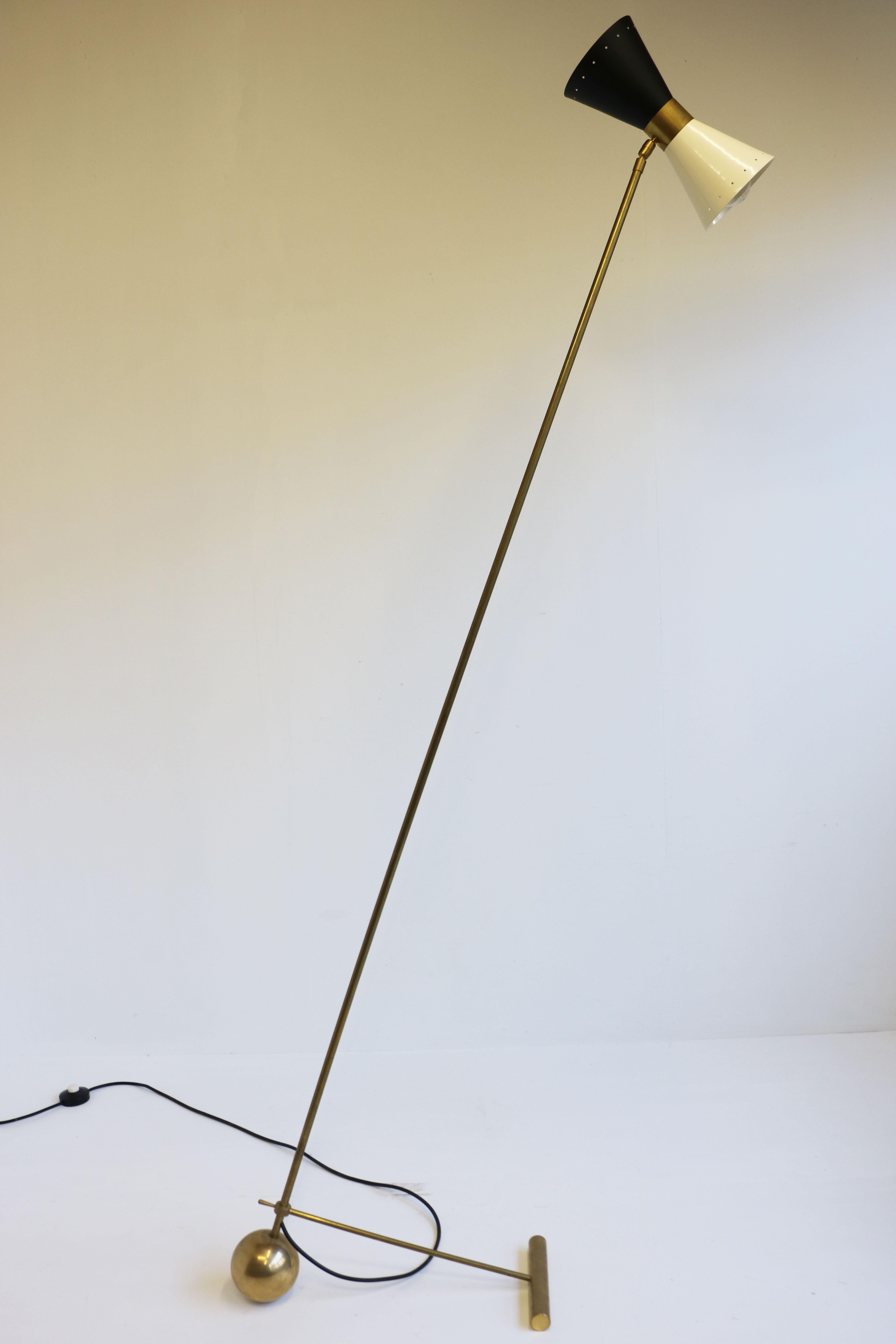 Superbe lampadaire de design italien minimaliste dans le style de Stilnovo 1950. 
Cadre en laiton patiné avec base au design minimaliste unique. Superbe abat-jour en forme de diabolo en noir et blanc. Un design intemporel ! 
L'angle du lampadaire