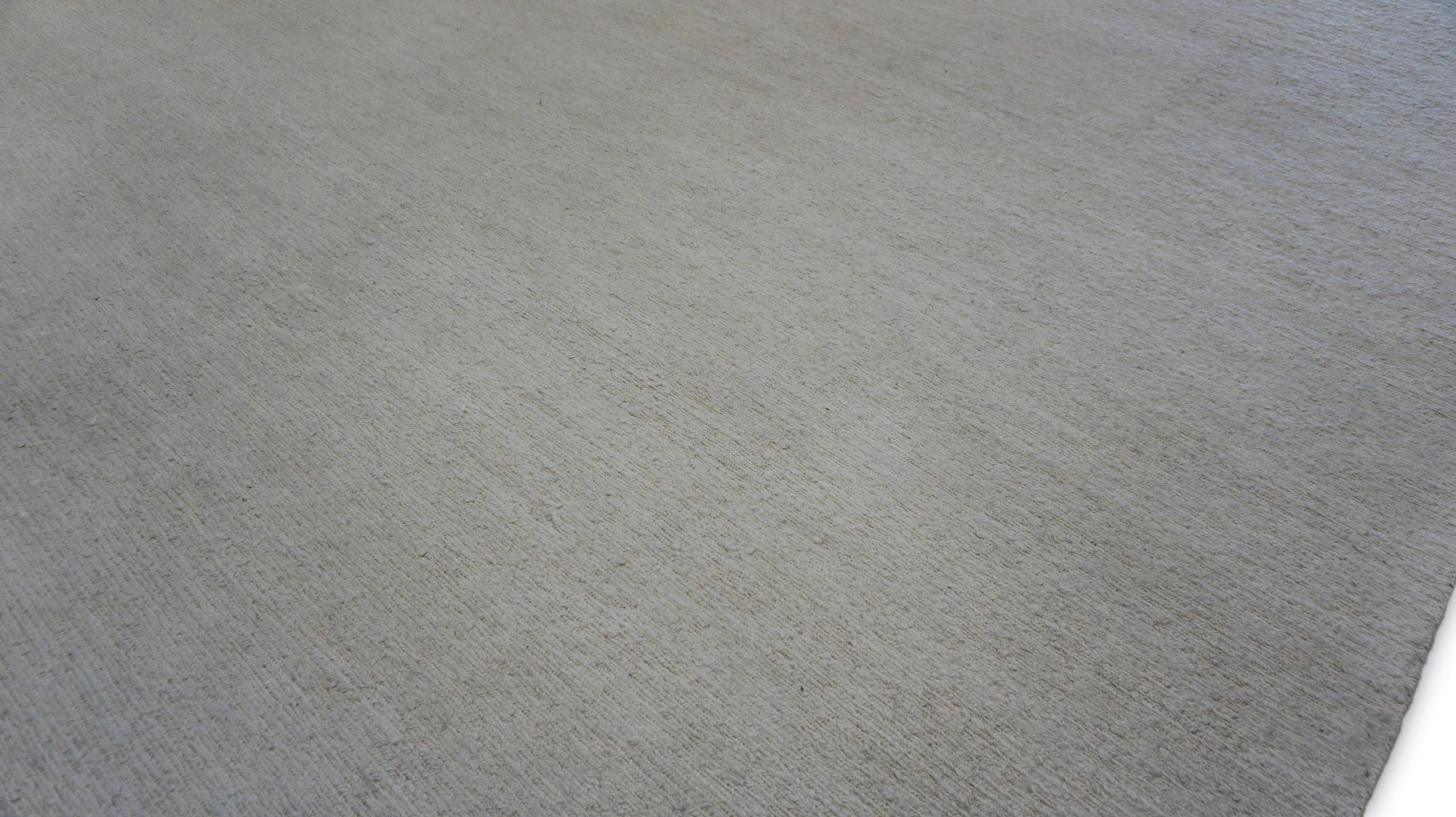 This elegant handwoven Soumack rug from Pakistan showcases the understated beauty of minimalist design. Crafted using the traditional Soumack weaving technique—renowned for its flat, braided texture—this rug features a soothing ivory tone that adds