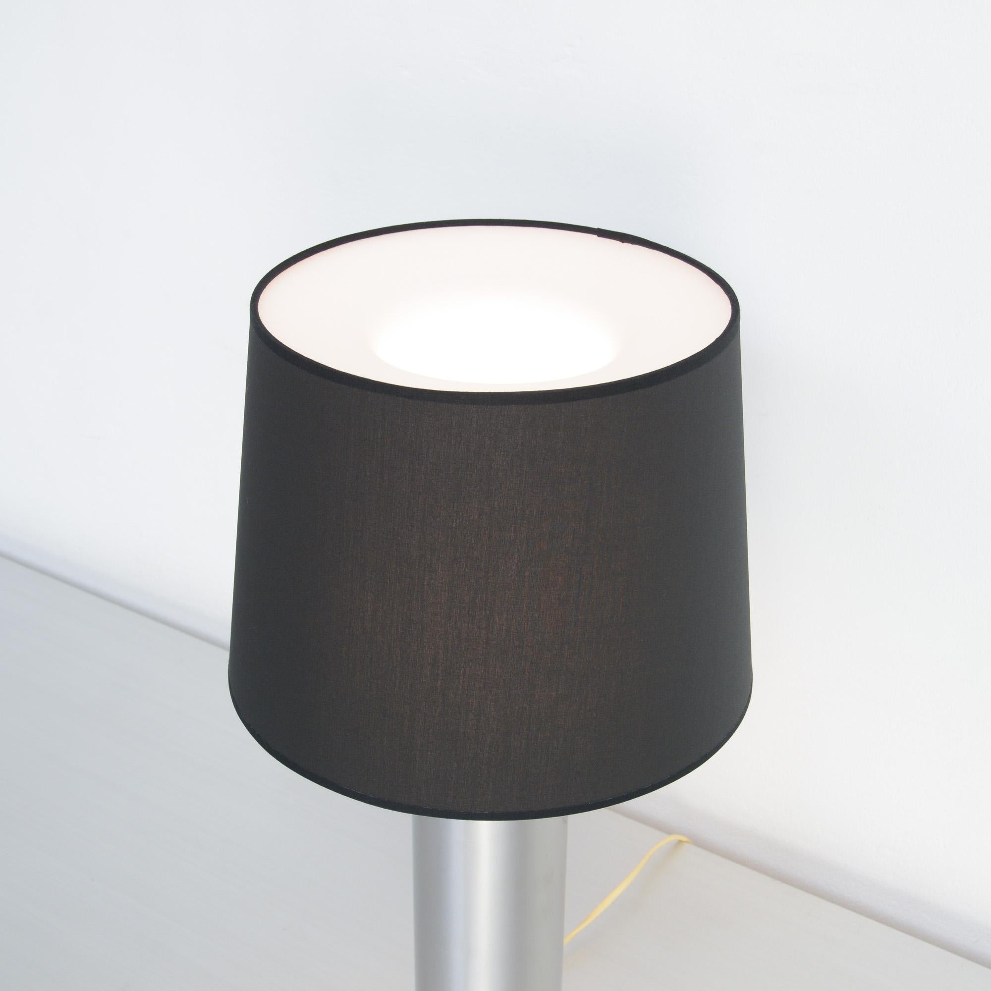 This Minimalist Scandinavian table lamp was designed by Uno & Östen Kristiansson for Luxus in Sweden in the 1960s.
This lamp is made of a chromed steel cylinder with rosewood details. The white perspex diffuser is covered with a black lampshade.