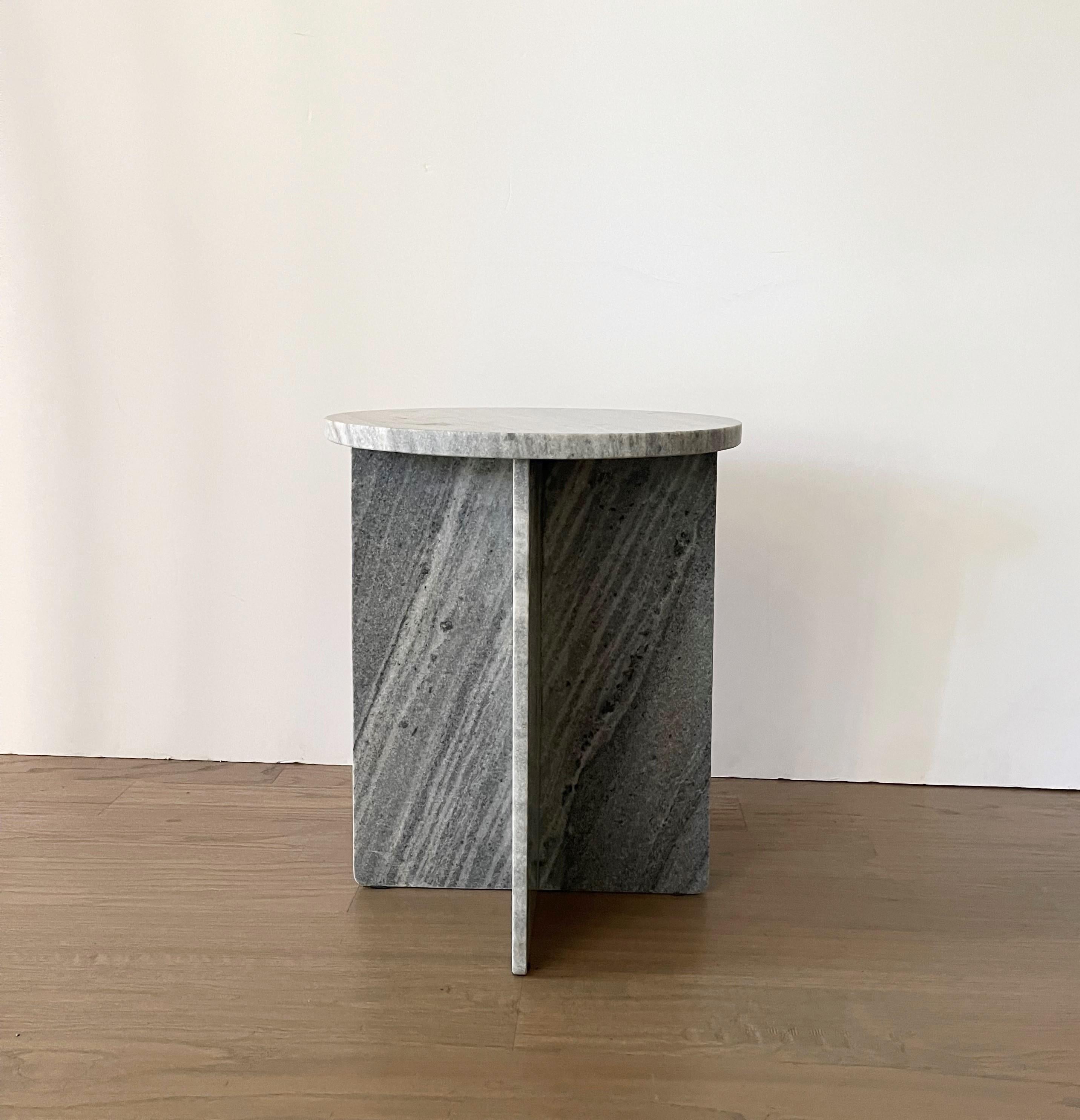 Gorgeous from every angle, crafted from solid marble this side table features a simple geometric silhouette, base made from flat panels making it as much a Minimalist work of art as it is a functional piece of furniture. The thick slab round top