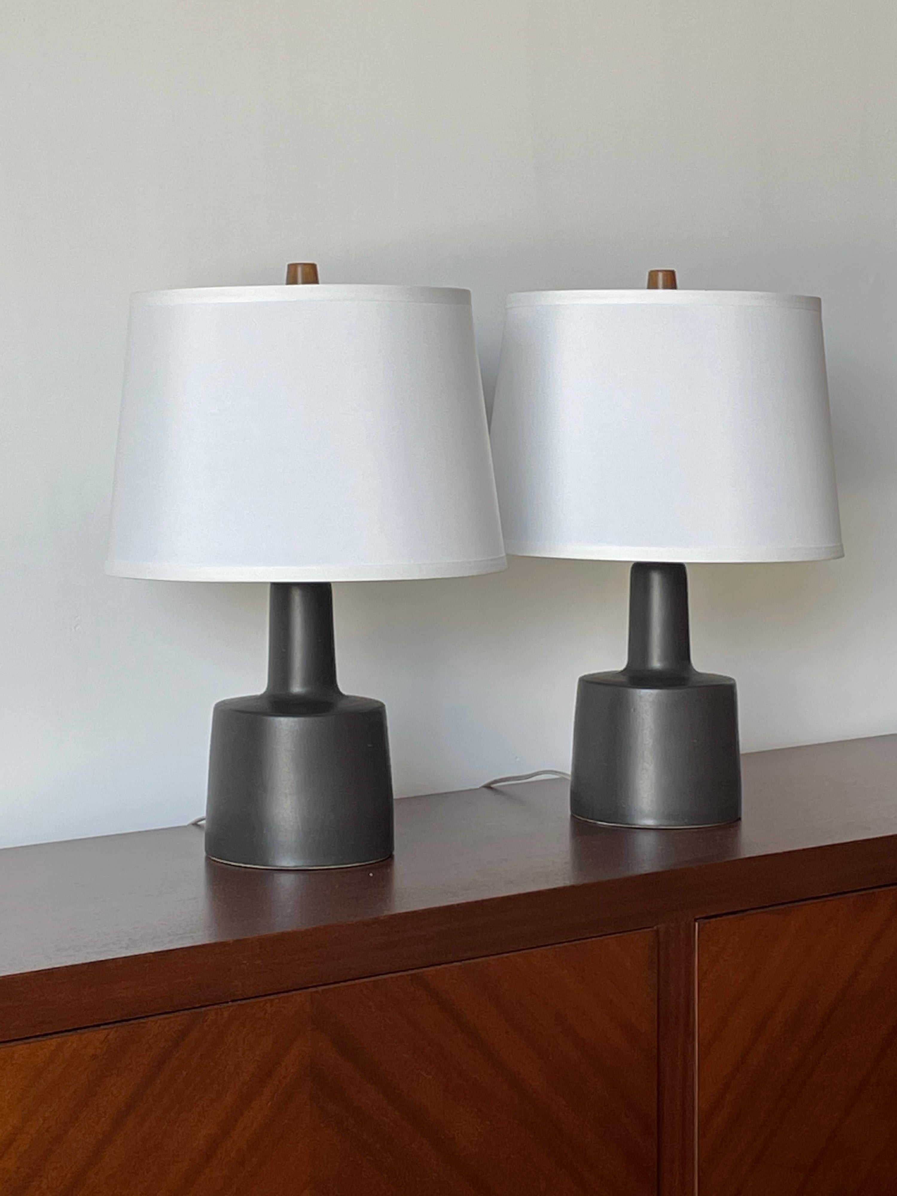 Wonderful pair of matte black ceramic table lamps by famed ceramicist duo Jane and Gordon Martz for Marshall Studios. Elegant and timeless design would work well in a variety of aesthetics- Boho chic, modern, mid century, contemporary,