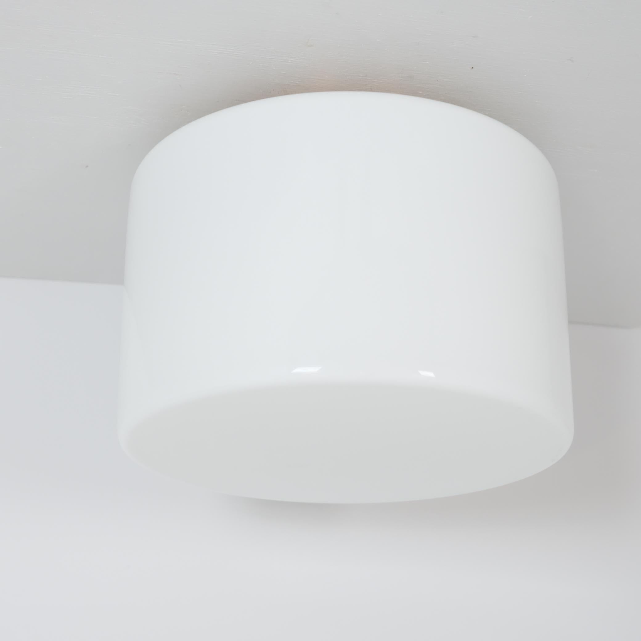 Una gran lámpara de techo minimalista modelo 2028 de Idman de la década de 1940. Este es el tamaño más grande de este modelo que aparece en el catálogo, con una pantalla de cristal de 35 cm de diámetro sobre una base de cobre que sostiene dos