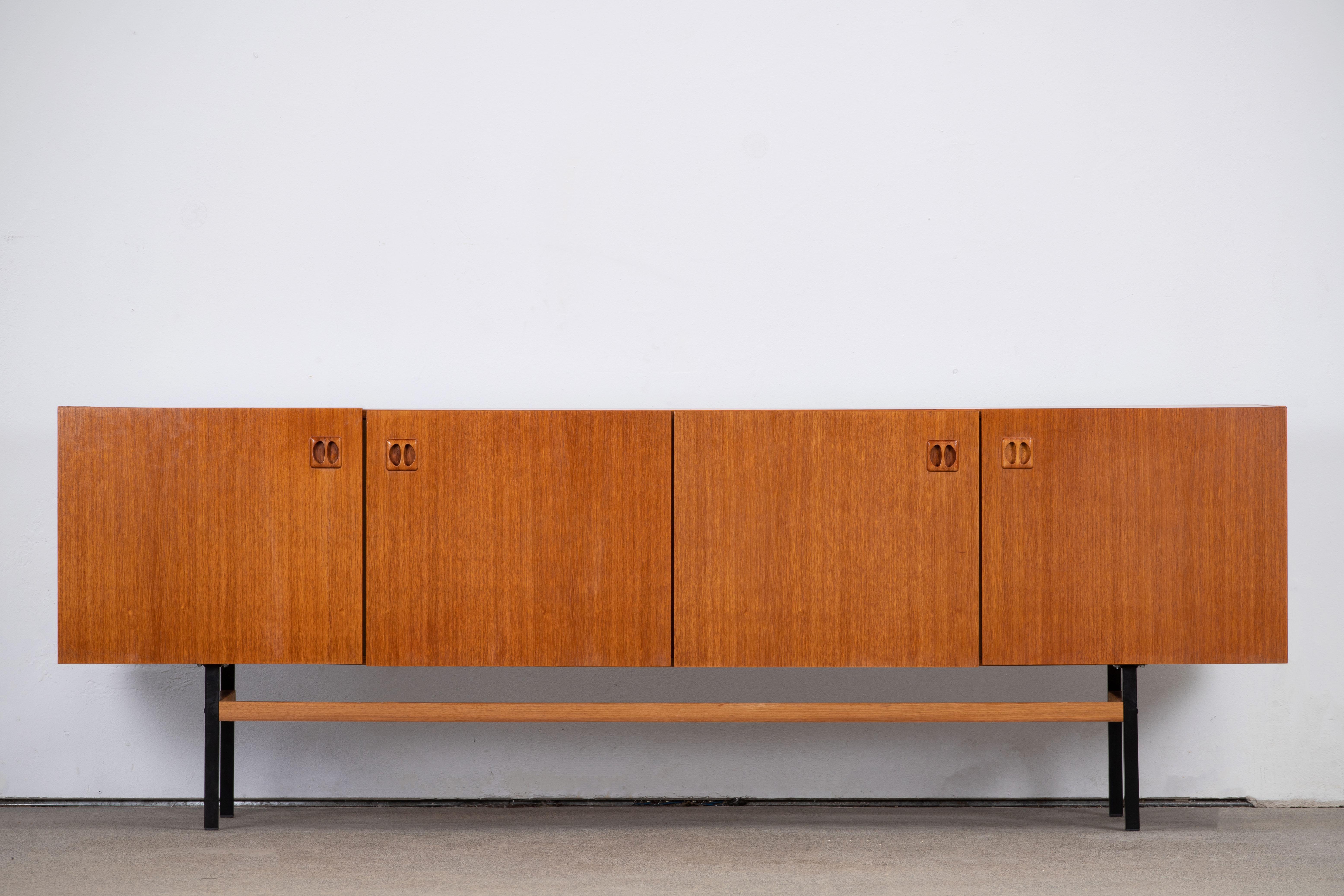 Midcentury teak sideboard from the 1960s. It is a shining example of the form and function synonymous with furniture of this era. Well-built, great design and lightness. Three drawers storage space. The minimal design and the warm tone combined with